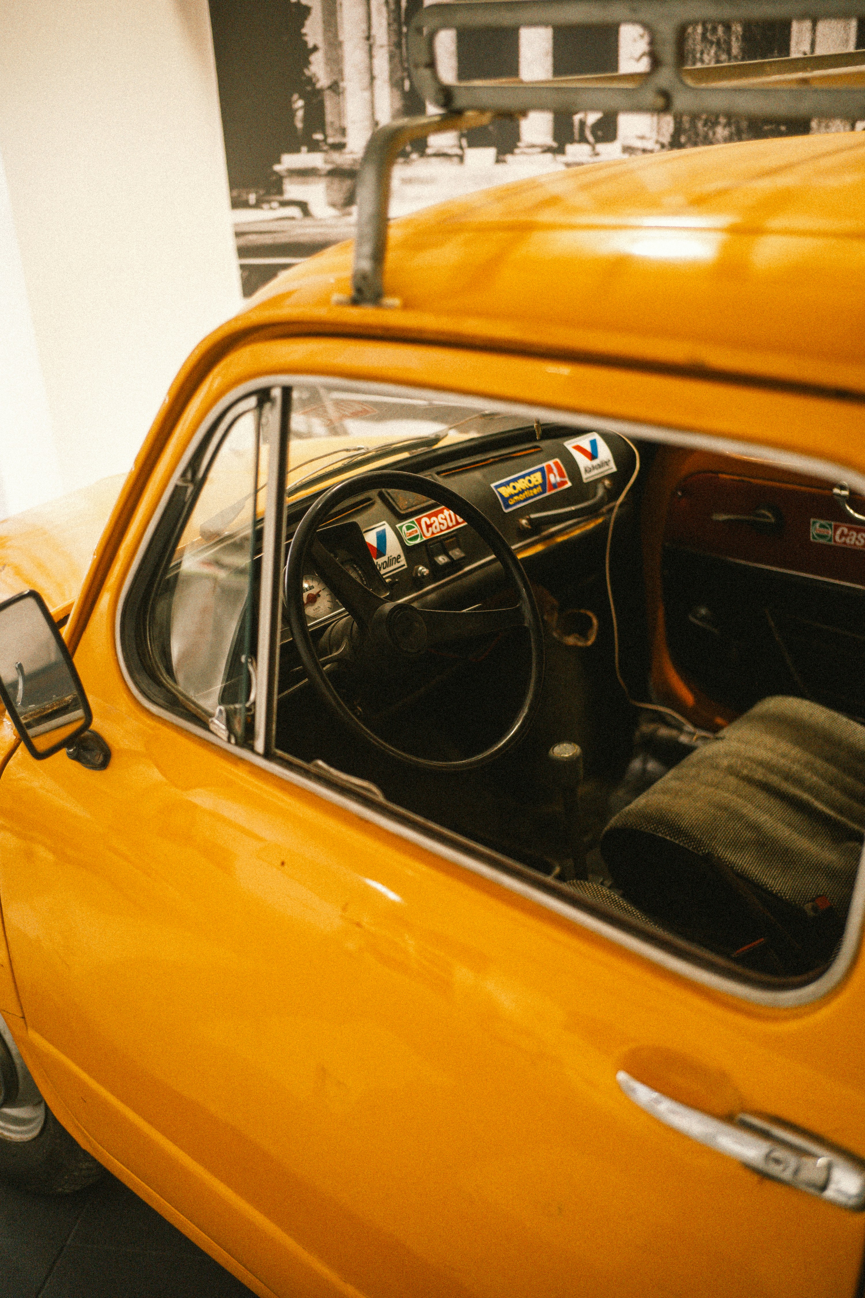 Bright yellow vintage car with roof rack and visible interior