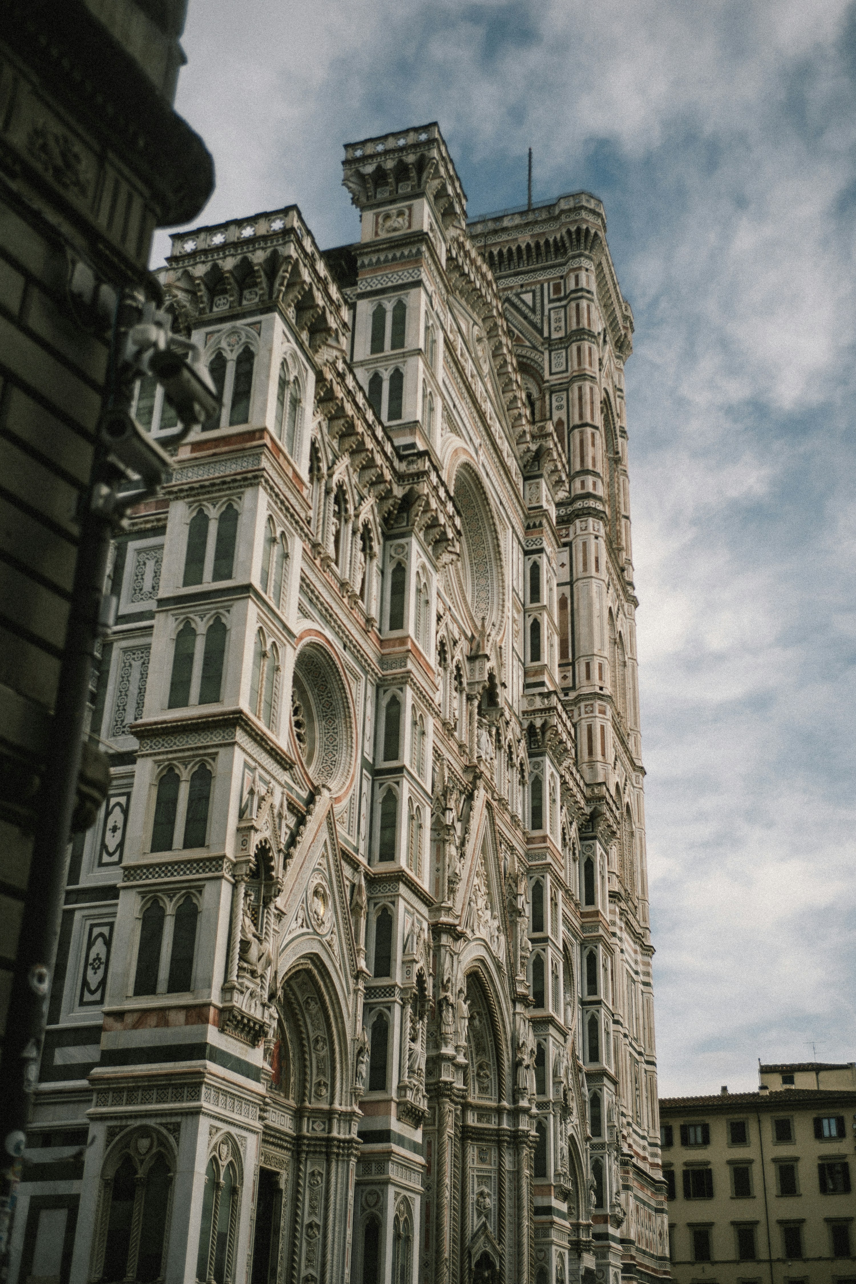Fachada histórica ornamentada de catedral que se extiende hacia un cielo nublado.