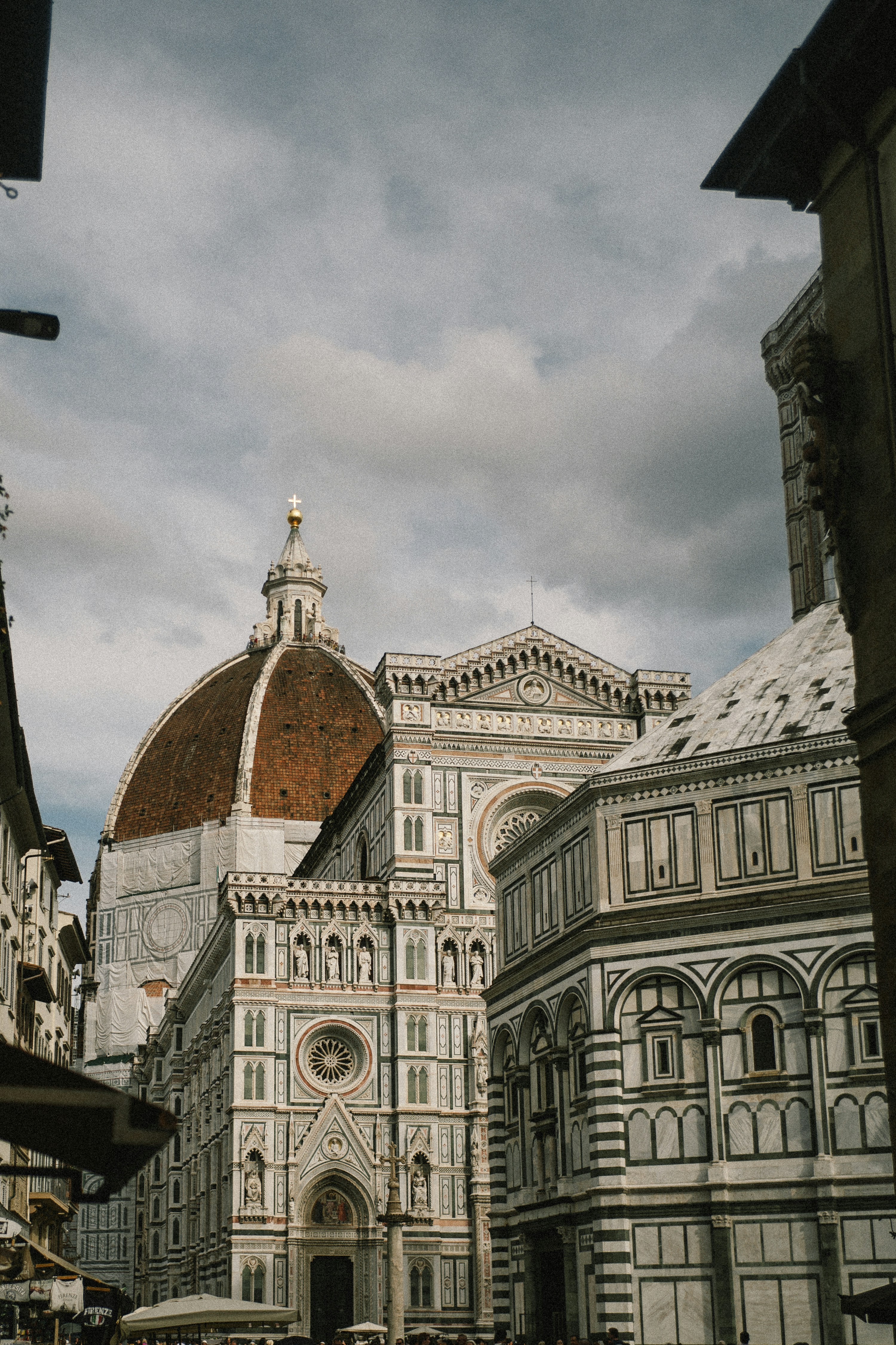 Catedral y baptisterio de Florencia bajo un cielo nublado.