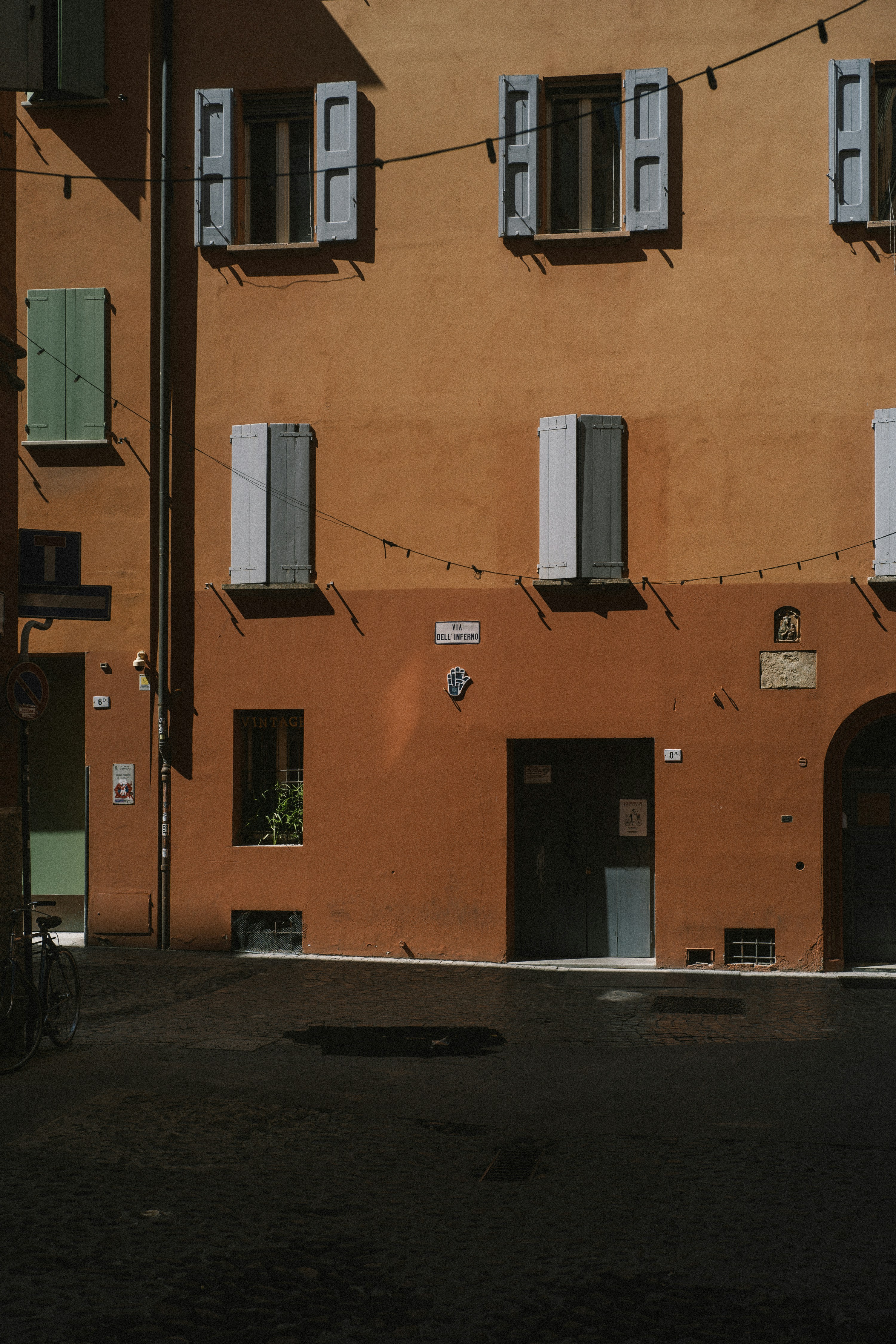 Terracotta building with colorful shutters under bright sunlight