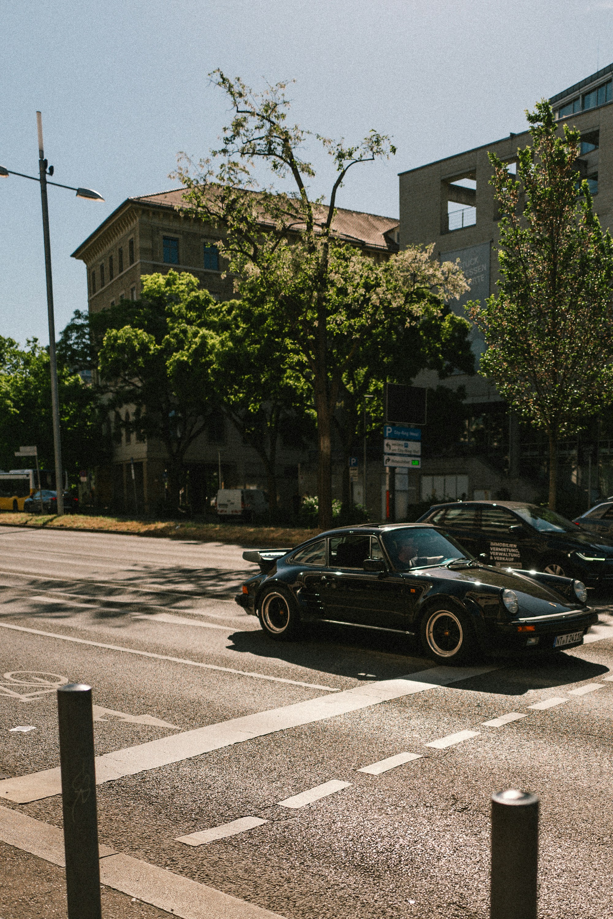 Vintage black sports car driving on a city street
