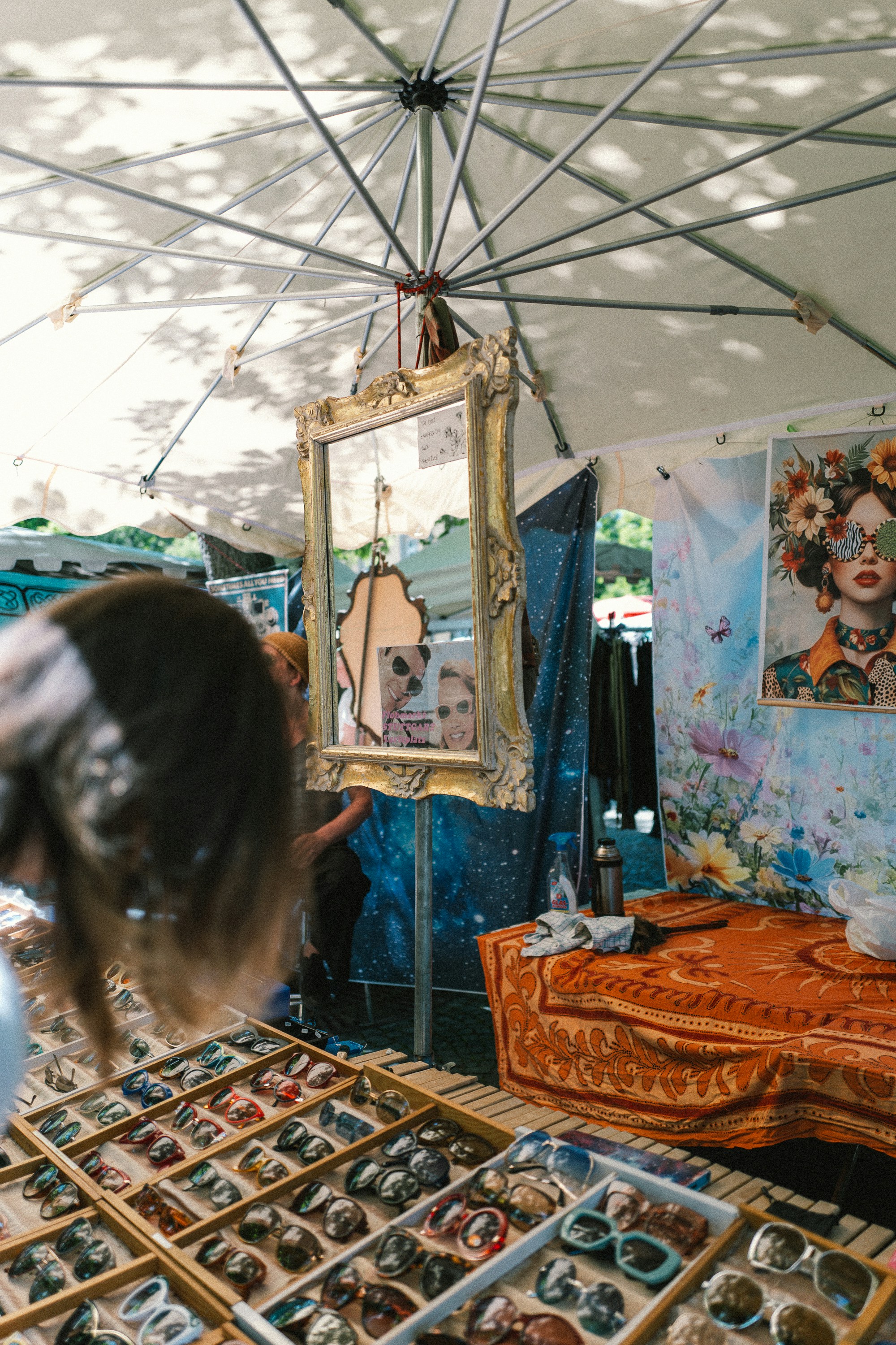 Sunglasses and an ornate mirror at a vibrant market stall