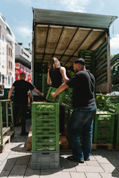 Trabajadores descargando cajones de verduras frescas para distribución mayorista en Mendoza