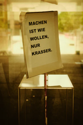 German text sign taped to a glass window.