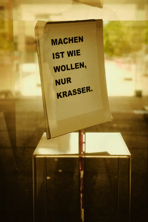 German text sign taped to a glass window.