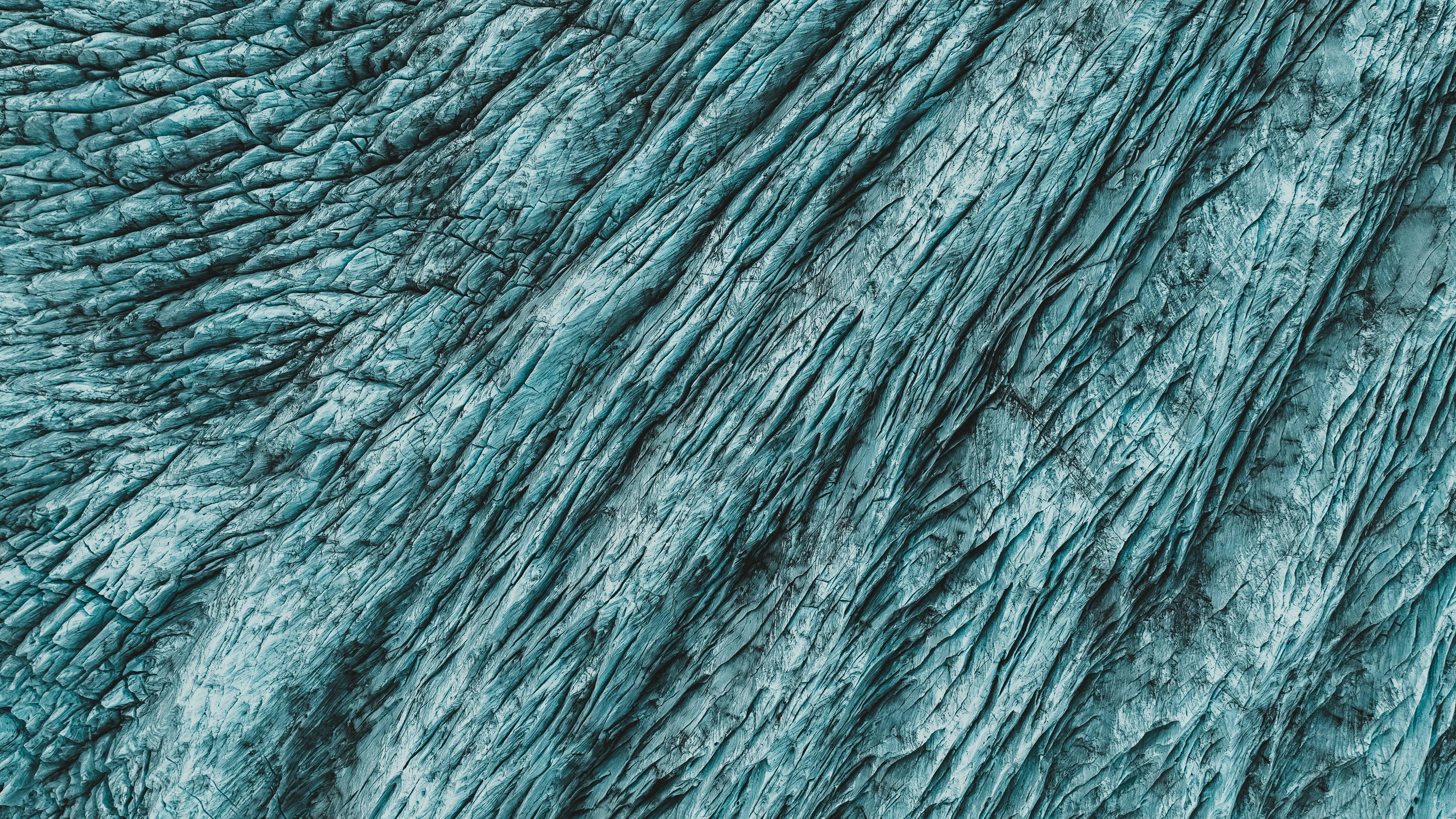 Textured blue-green glacial ice surface