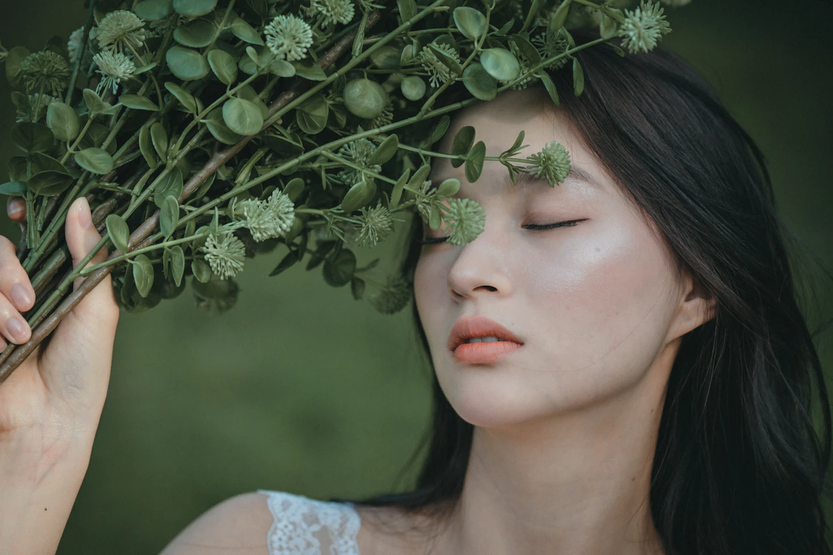 Woman with clear, glowing skin among green leaves – Korean skin care treatments at JIA Skin Clinic Gangnam