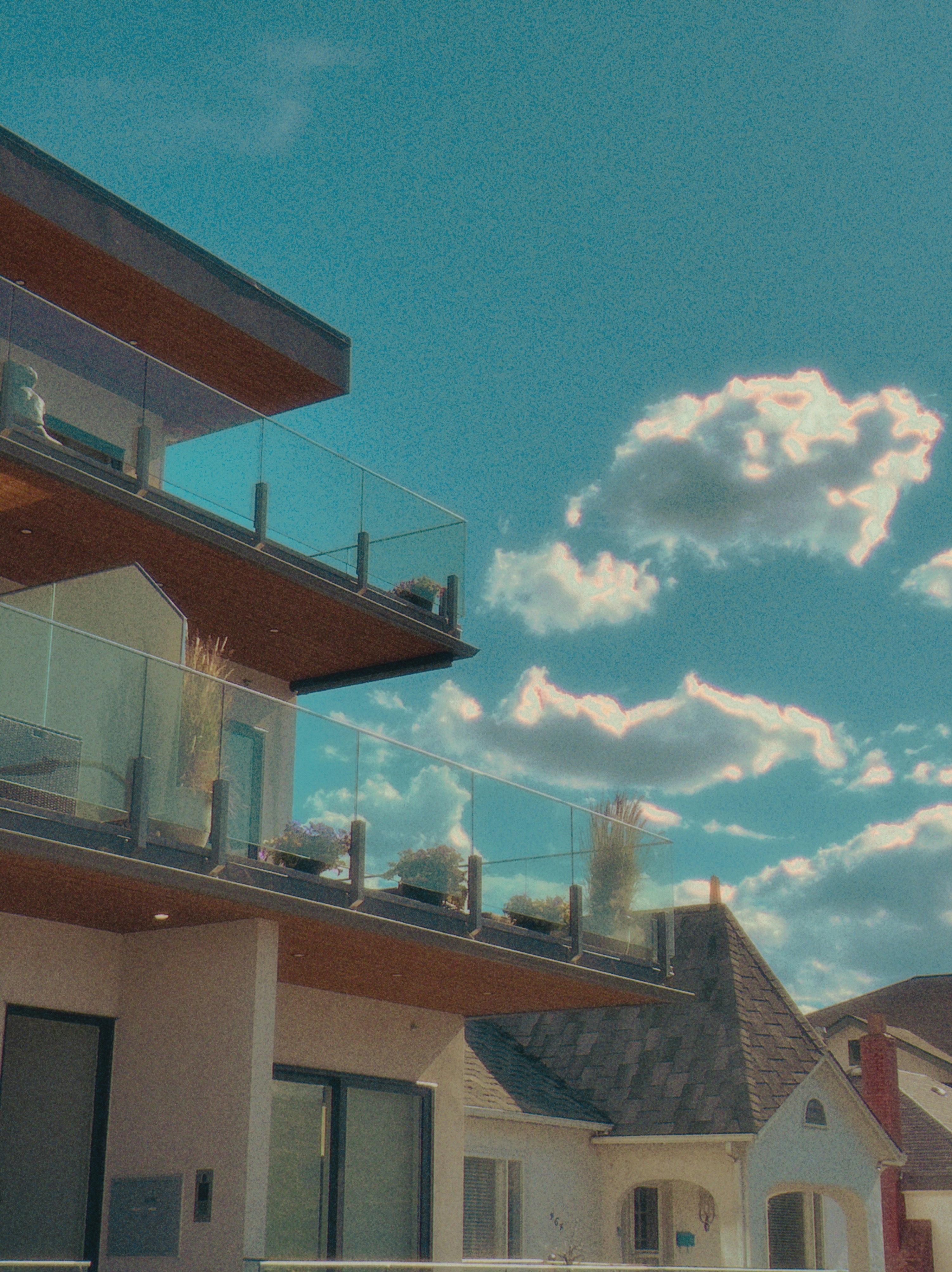 Modern building balconies under a bright blue sky with clouds