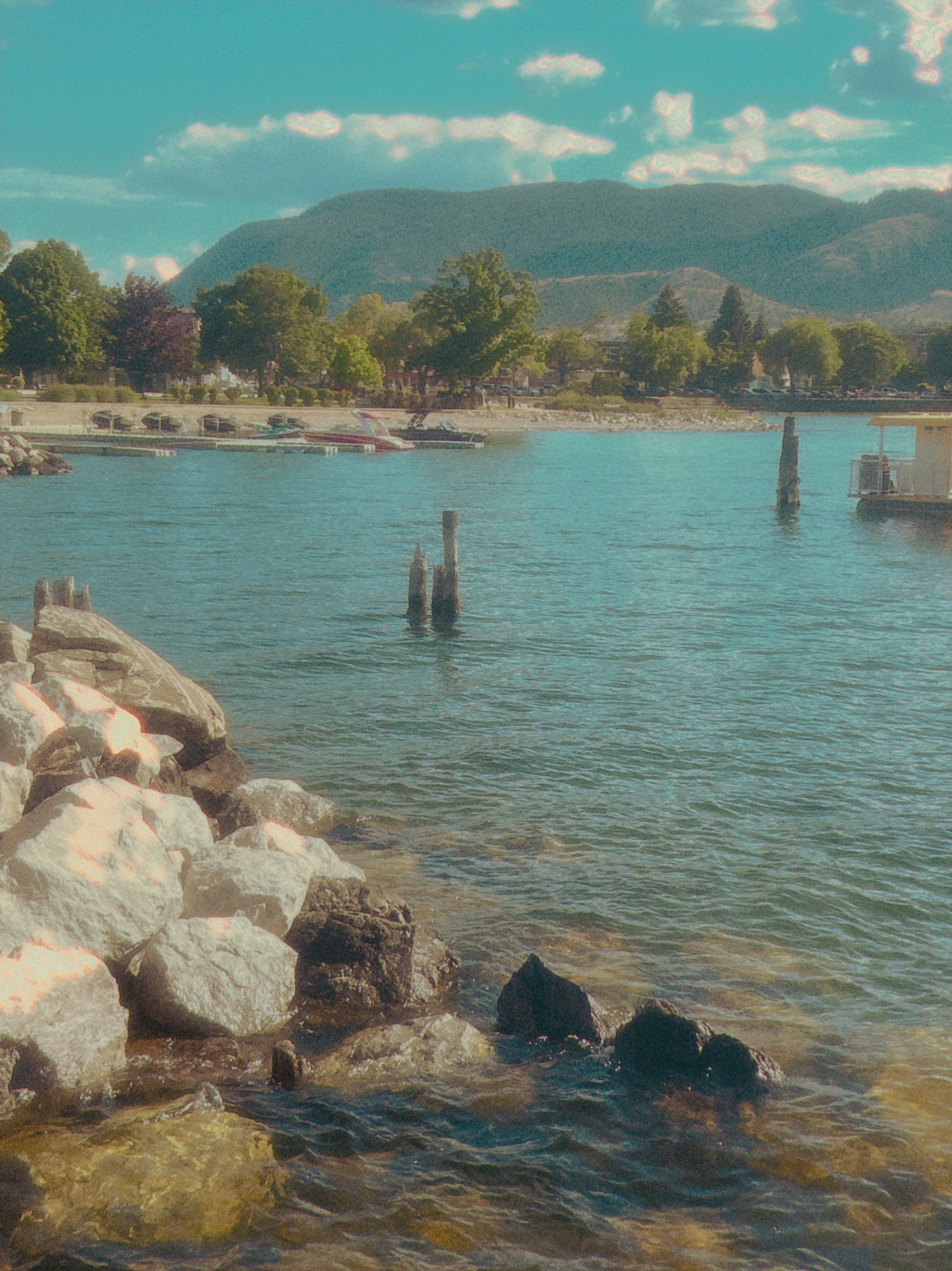Calm lake water with rocky shore and distant mountains