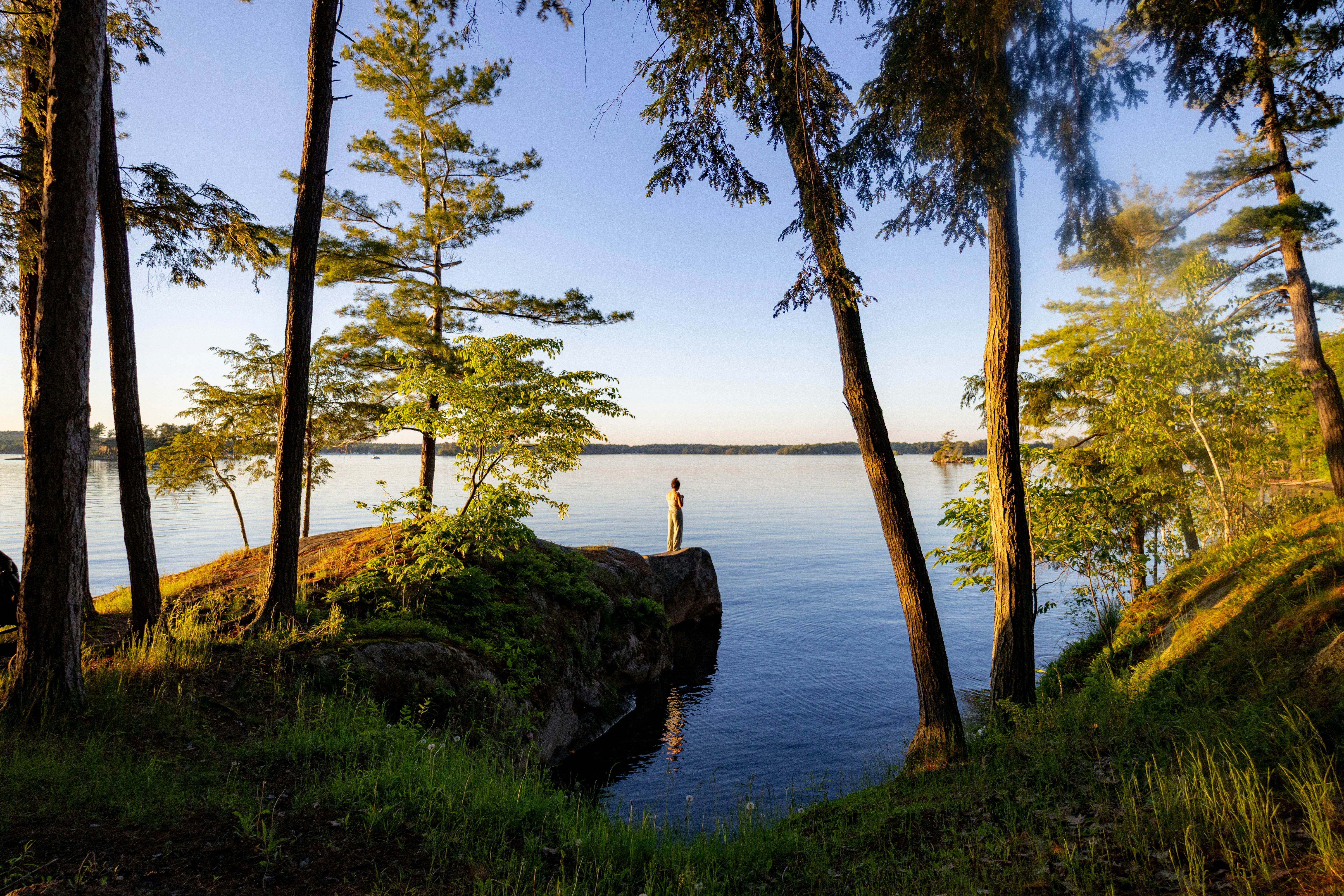 Vue paisible sur le lac avec une personne au bord d’un rocaille.