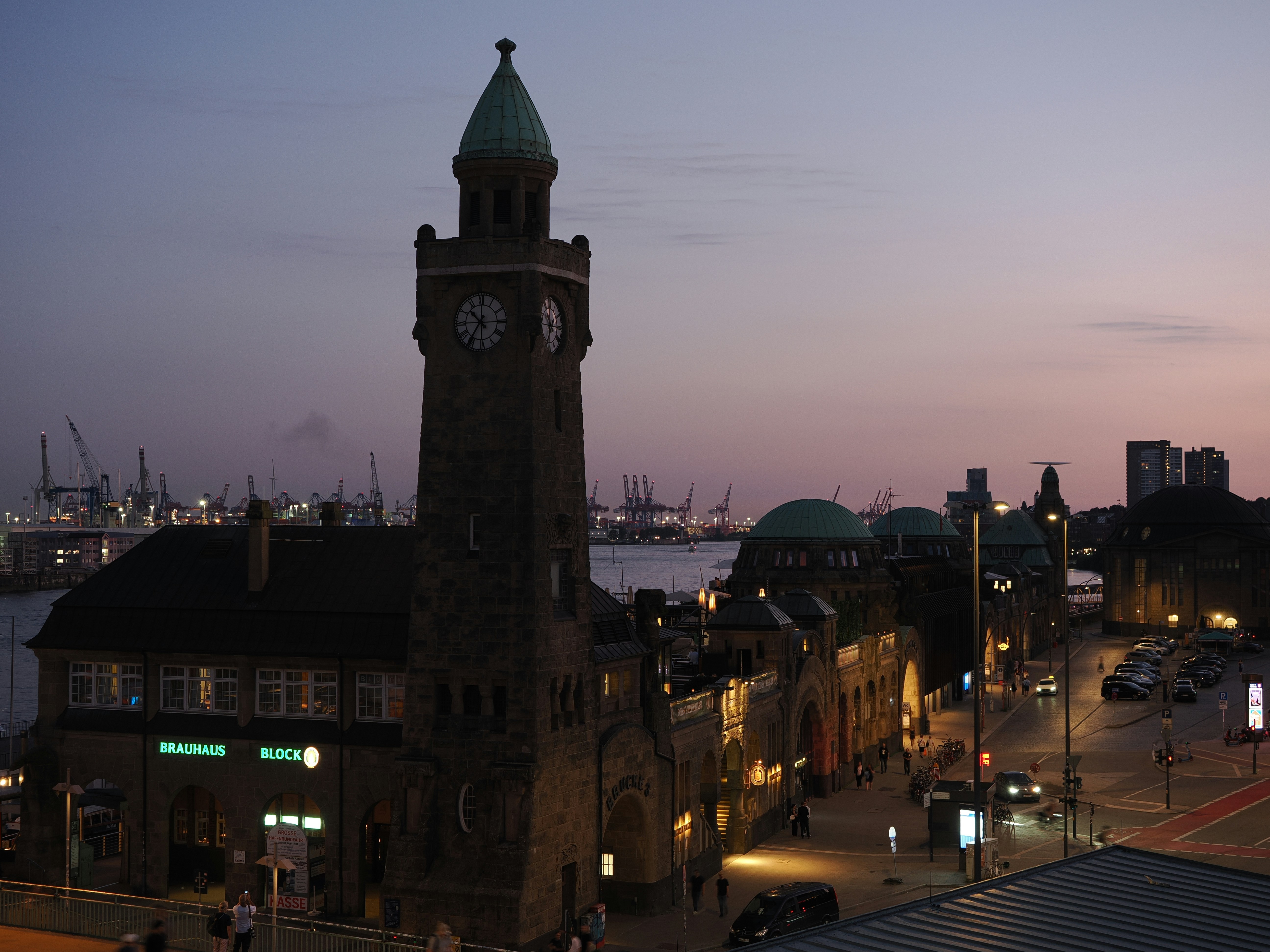 Historic clock tower and city harbor at twilight.