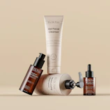 Various skincare and beauty products arranged on a beige background.
