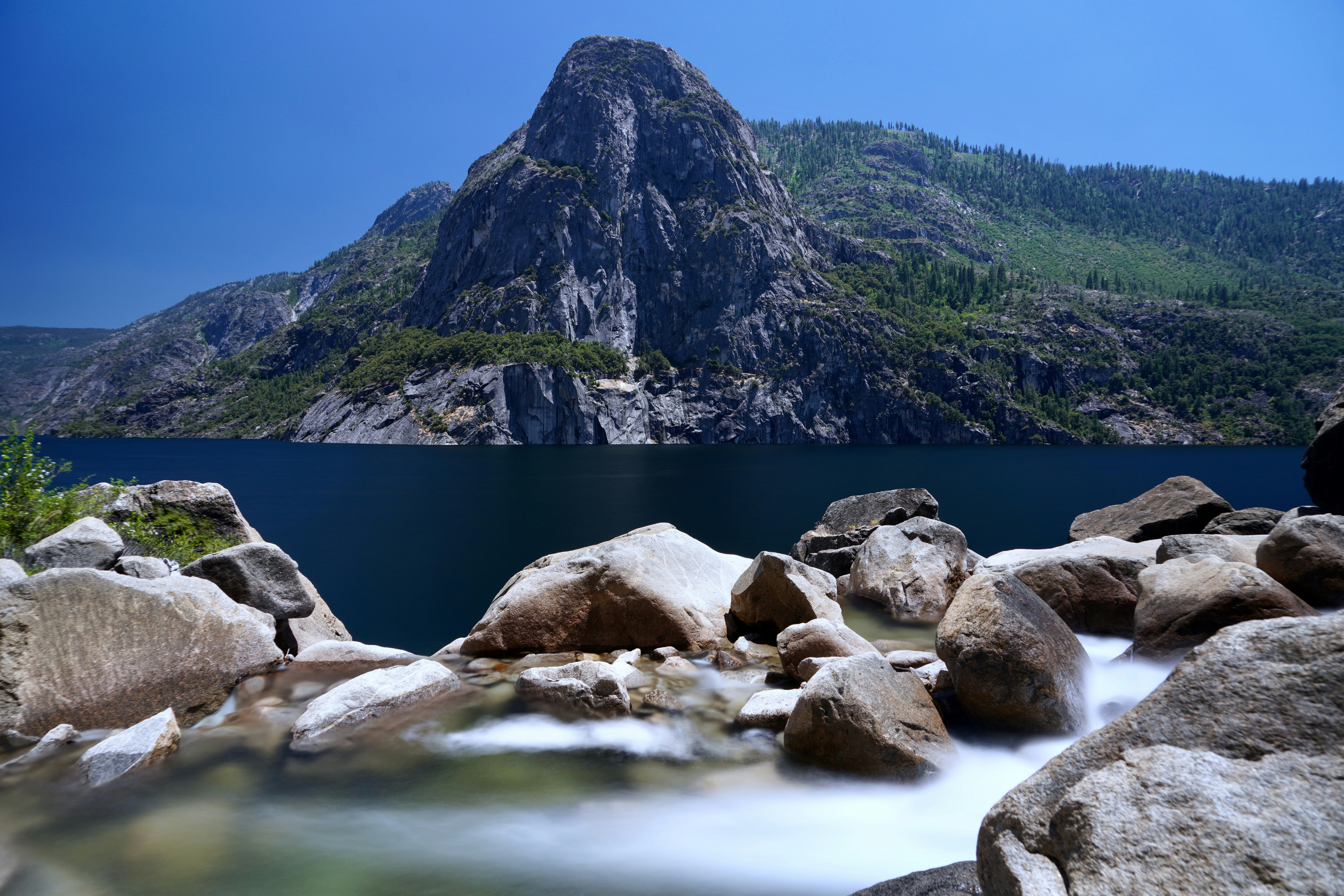 Felsige Berglandschaft mit einem ruhigen See und fließendem Wasser