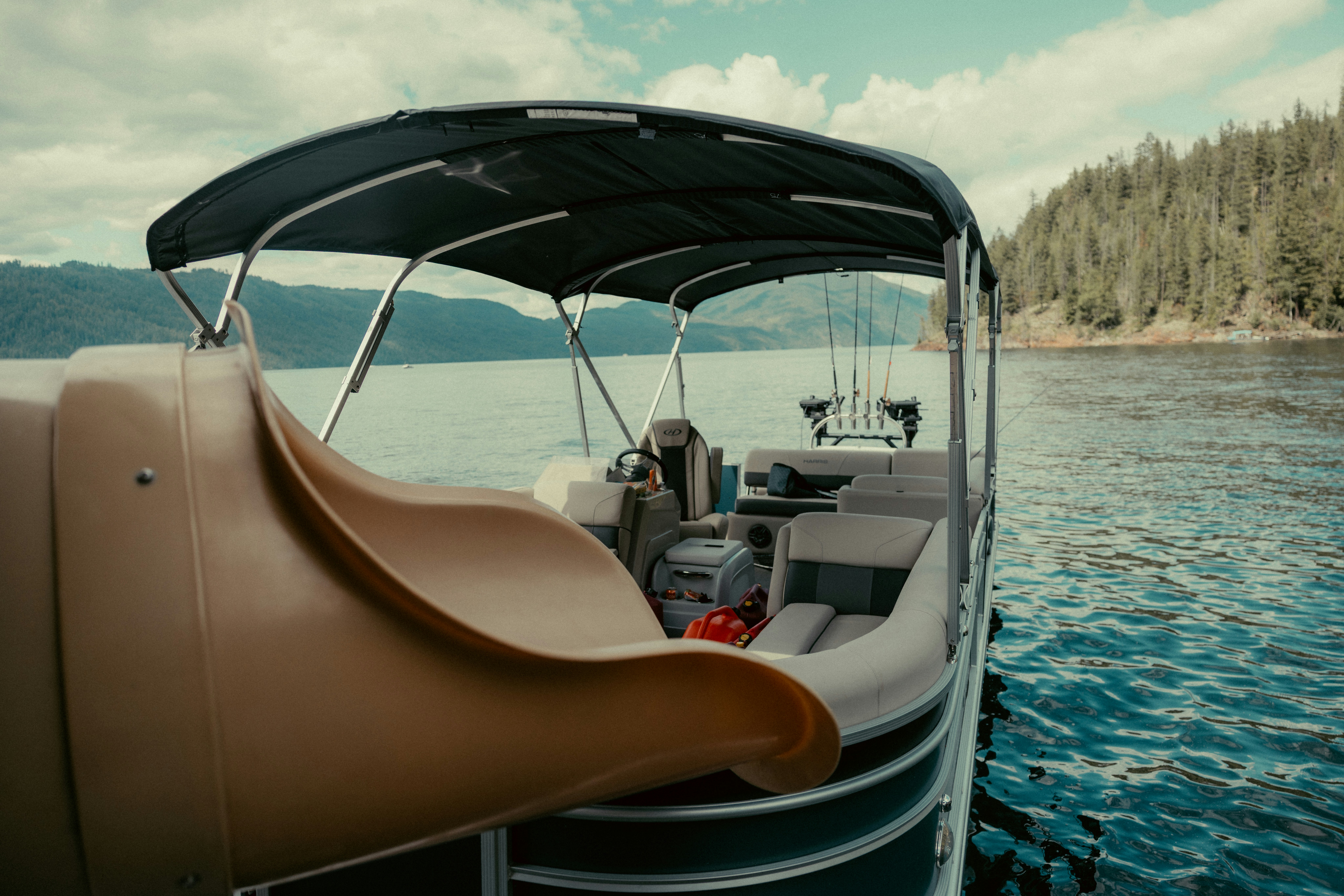 Pontoon boat with a slide on a calm lake.