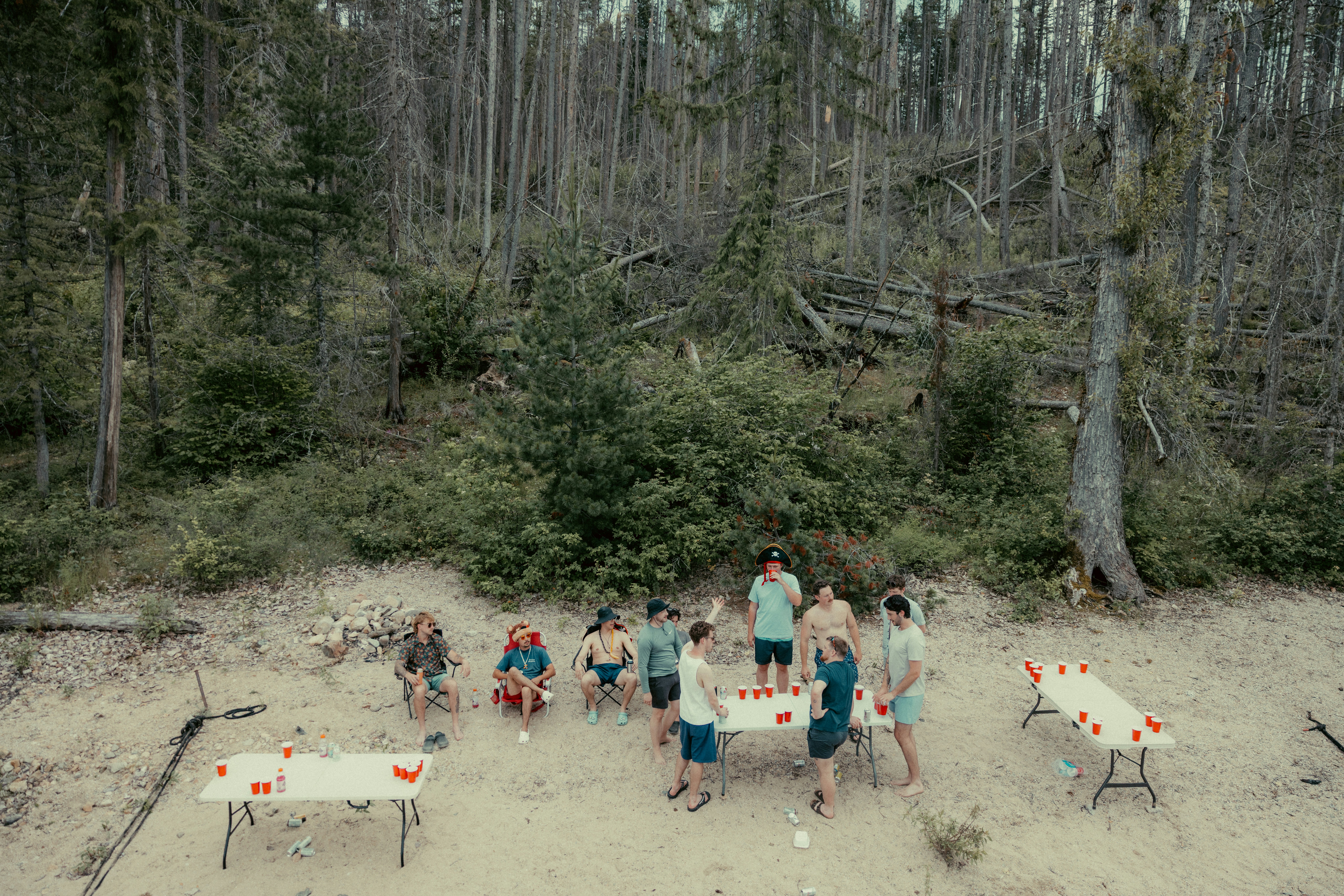 Group playing games with red cups in a forest clearing.