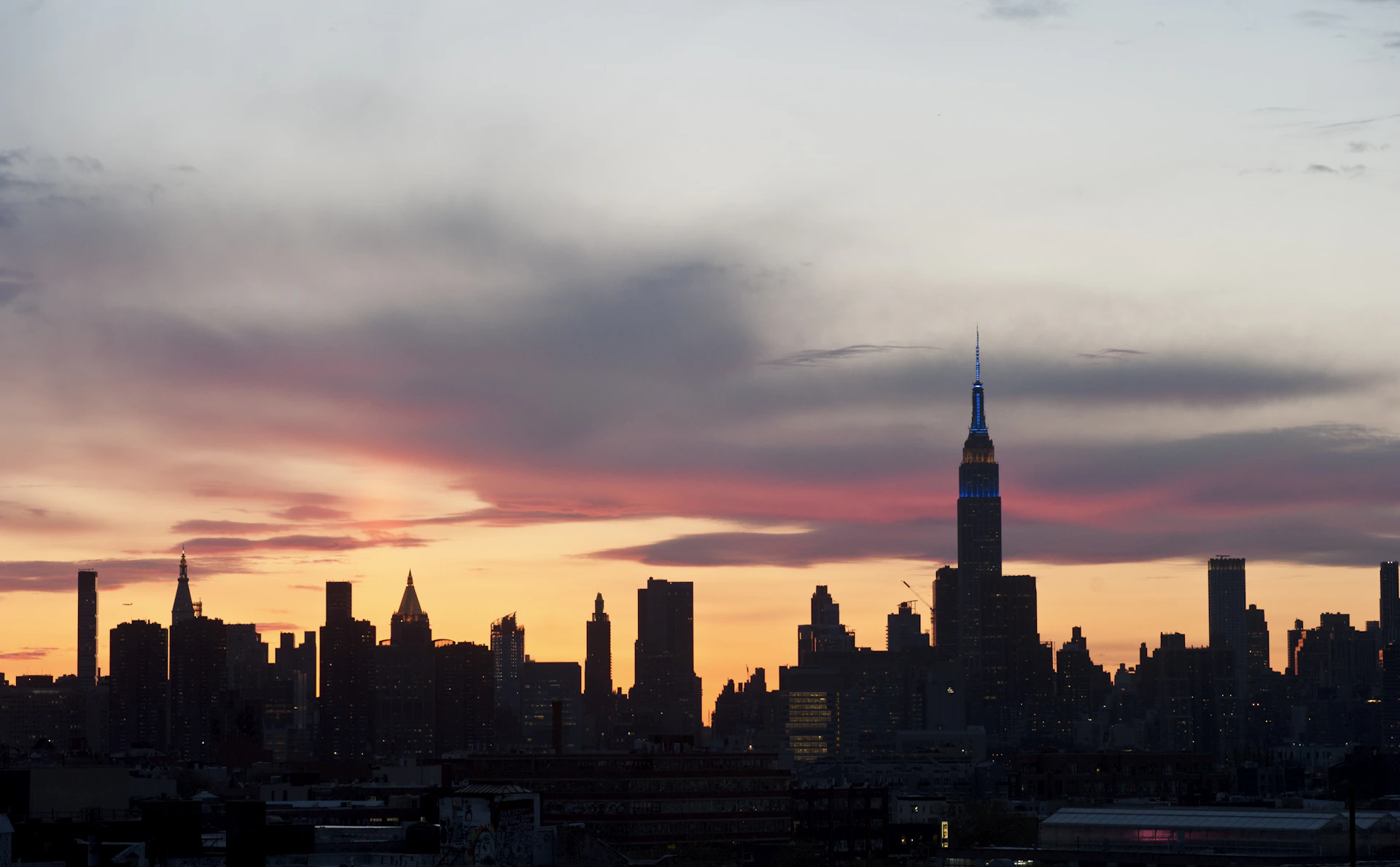 City skyline silhouetted against a vibrant sunset sky.