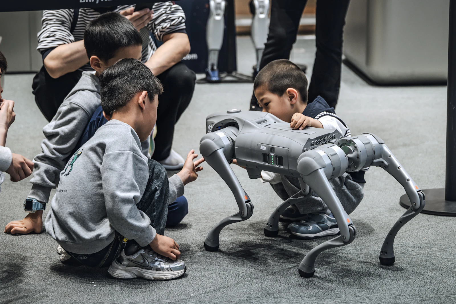 Children gathered around a robot dog