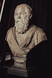 A marble bust of socrates on a dark background