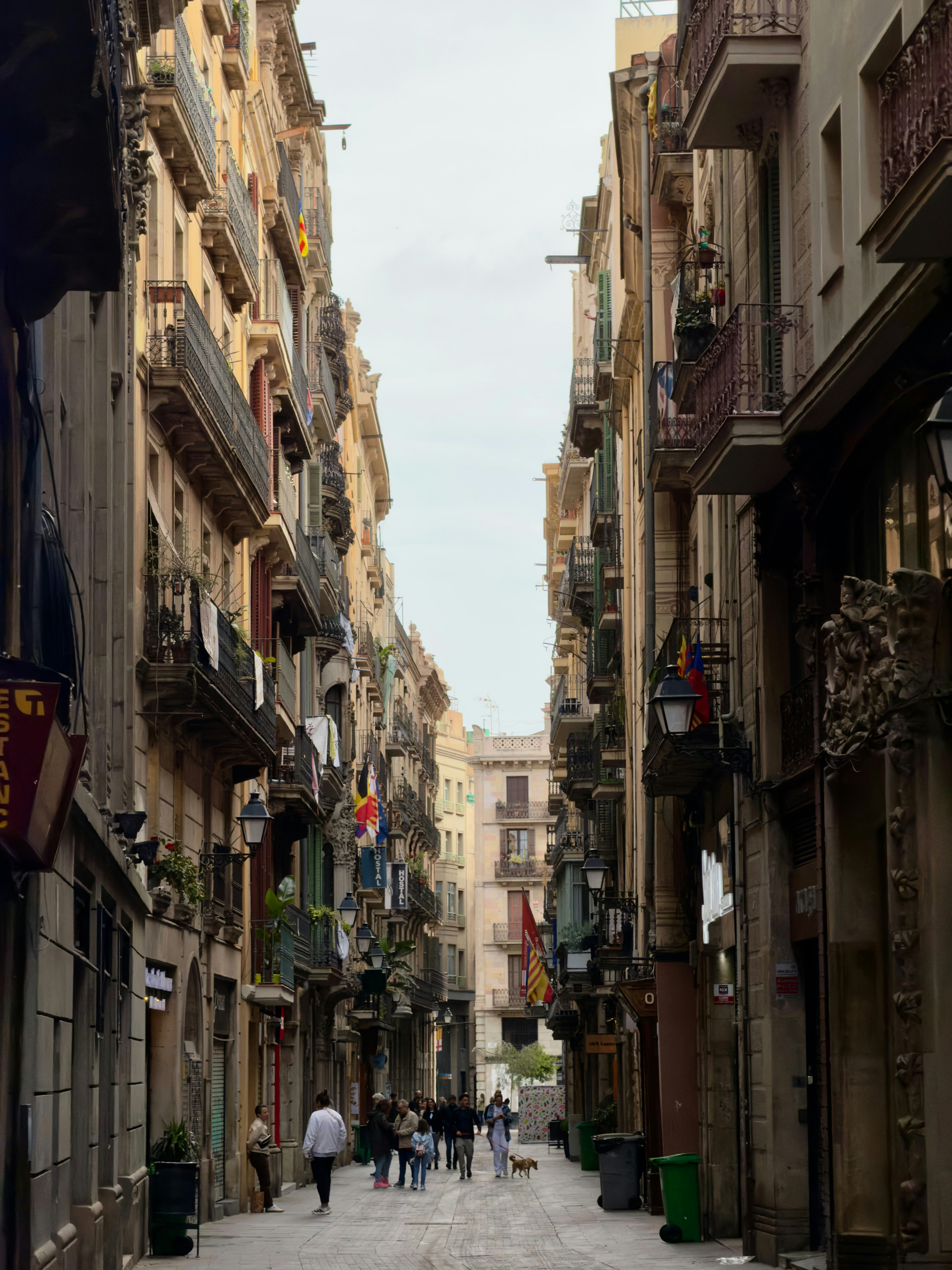 Historic european street with tall buildings and pedestrians.