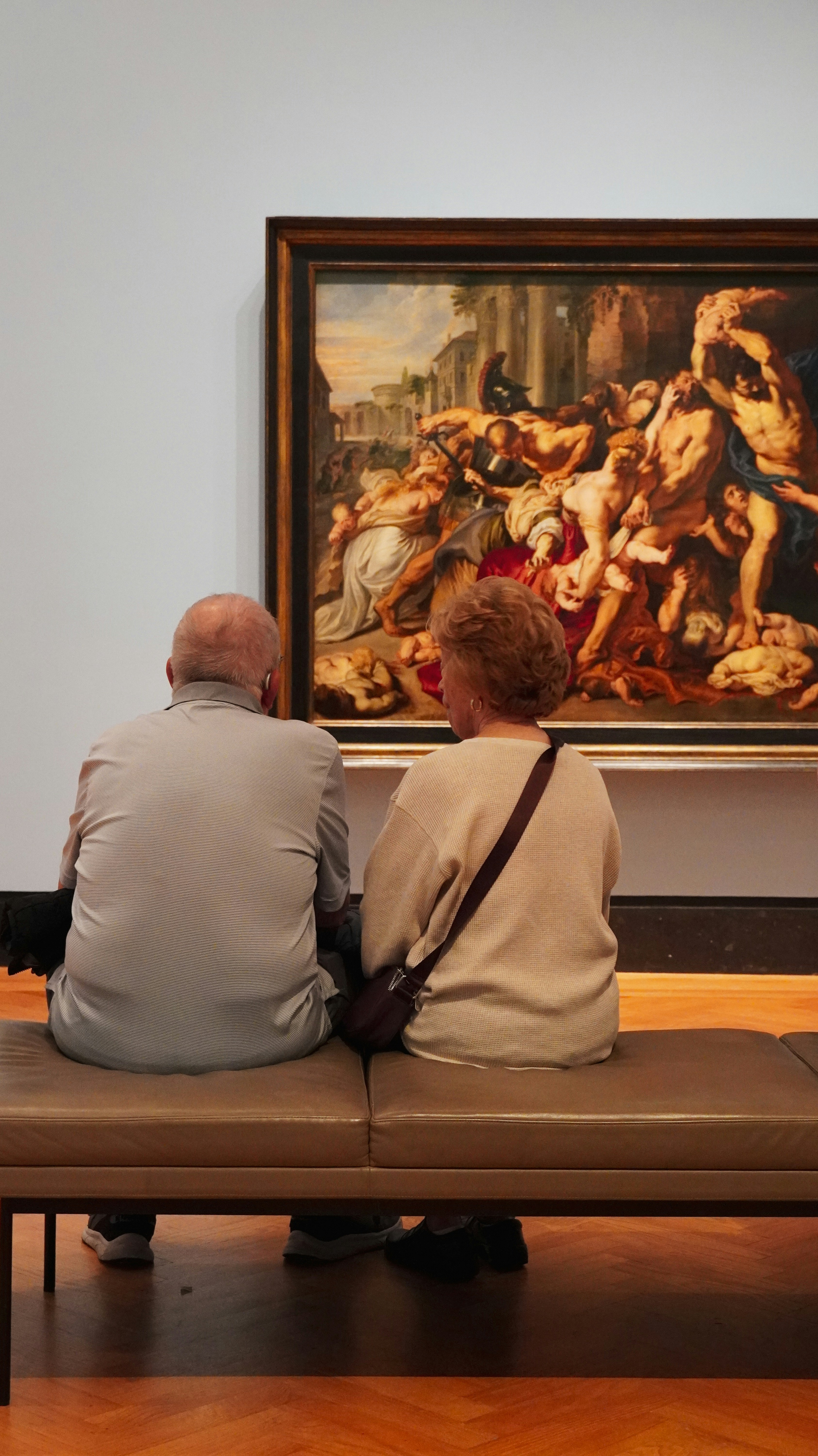 Elderly couple viewing a large painting in an art gallery