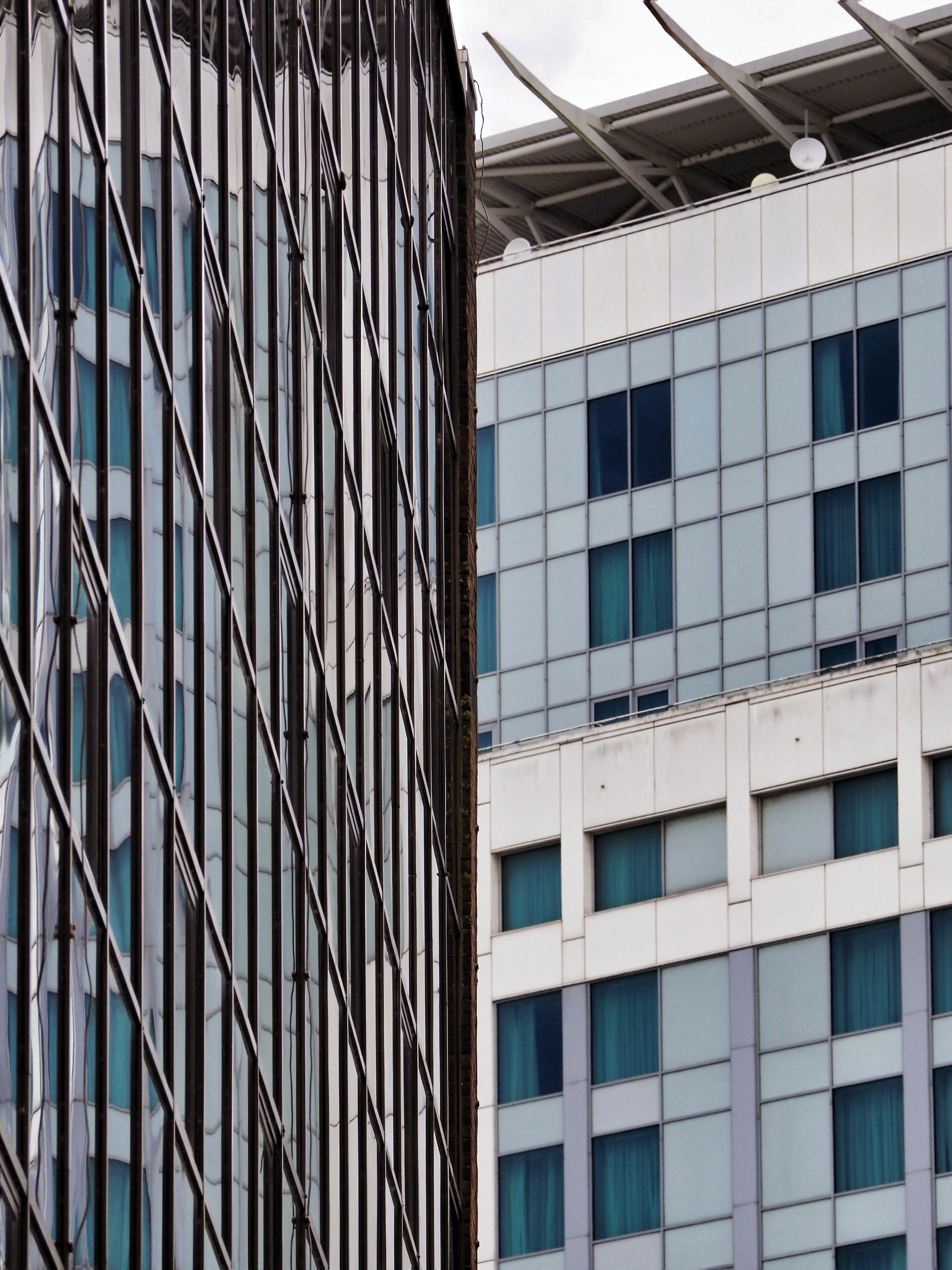 Modern glass buildings featuring reflective surfaces and a rooftop helipad.