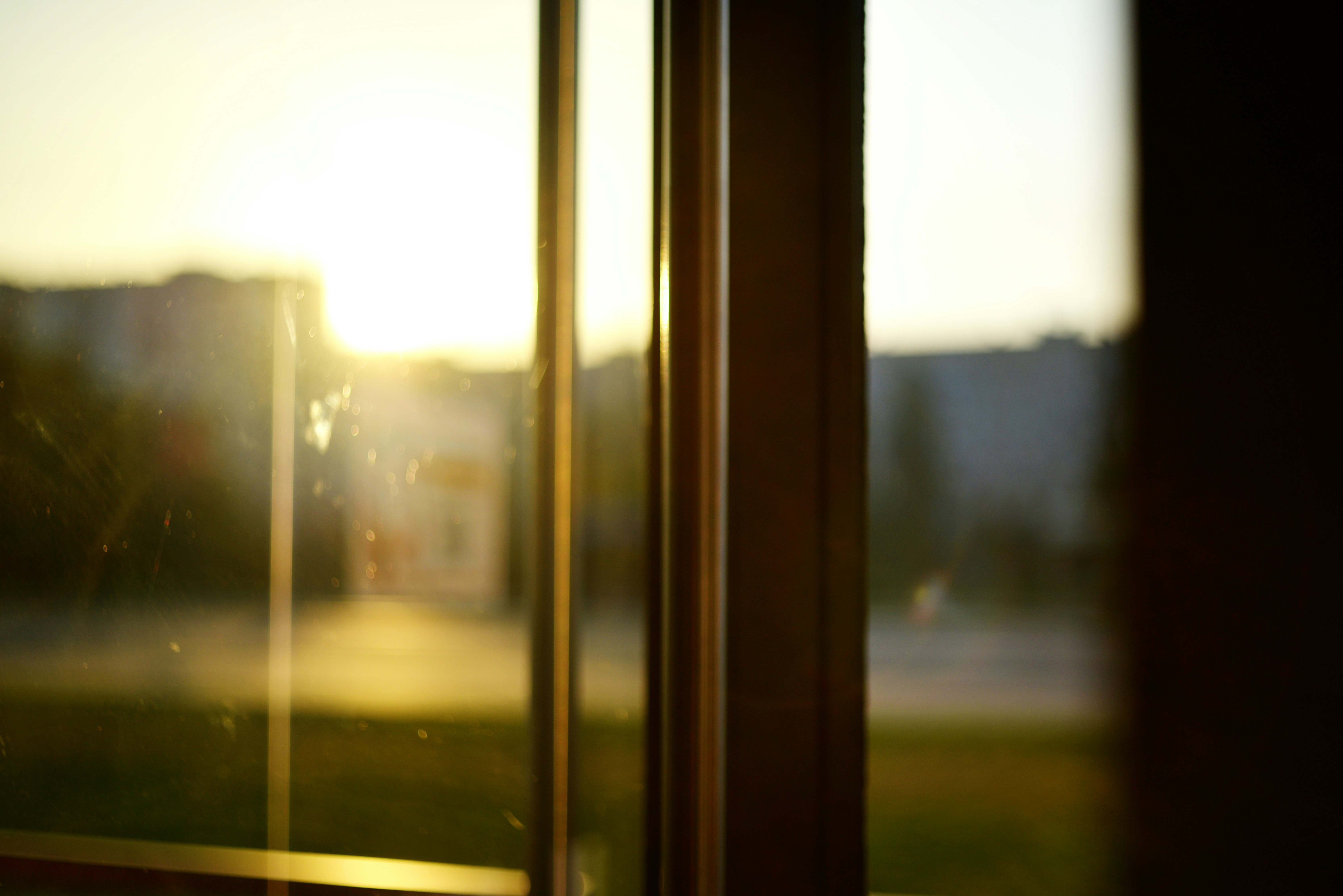 Goldenes Licht fällt durch ein Fenster mit Blick auf eine verschwommene Stadt