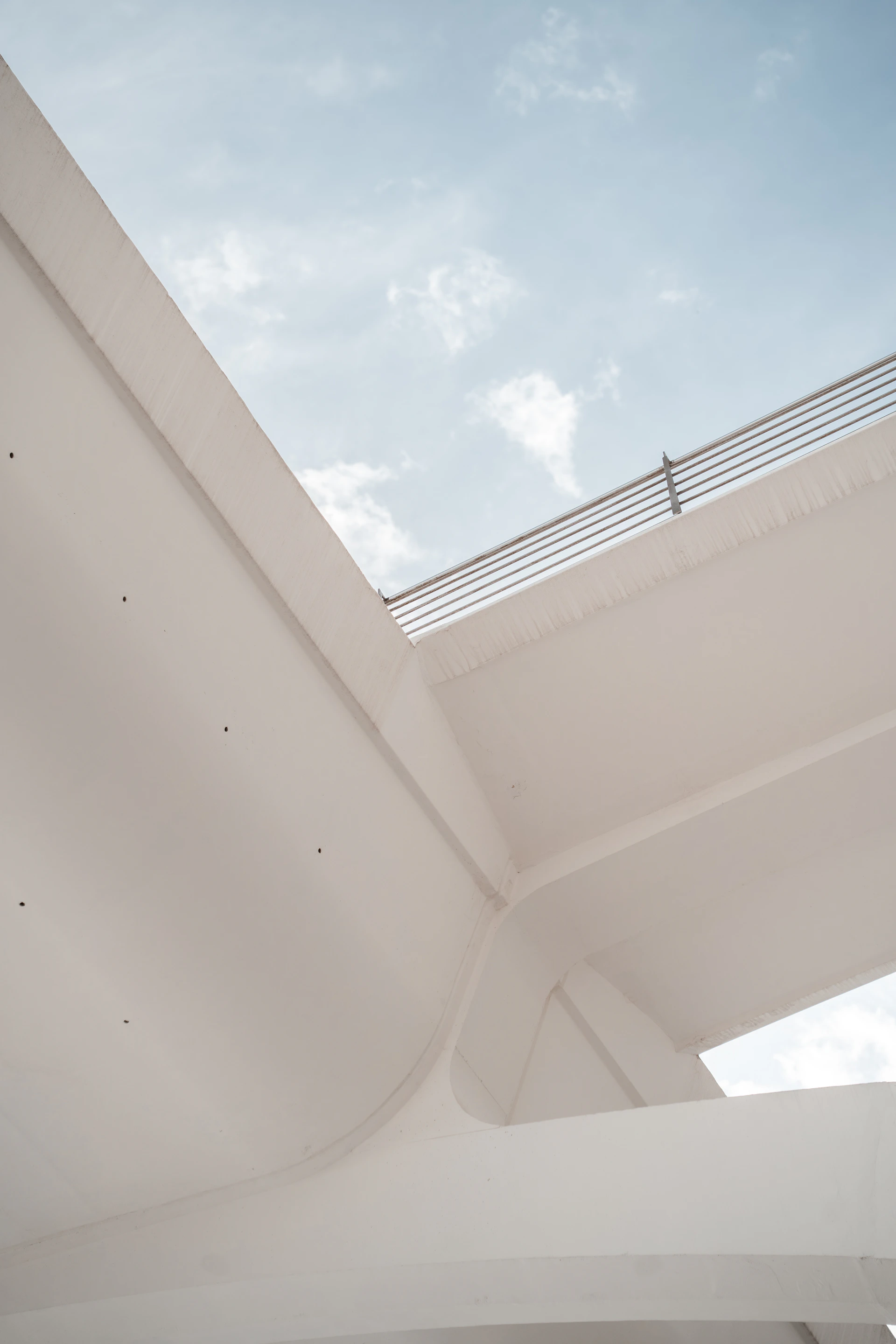 Modern white architecture against a blue sky with clouds