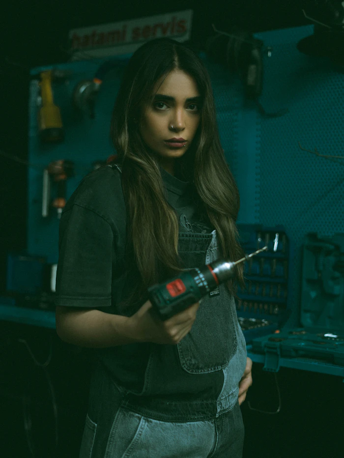 Leila holding a cordless drill in the workshop
