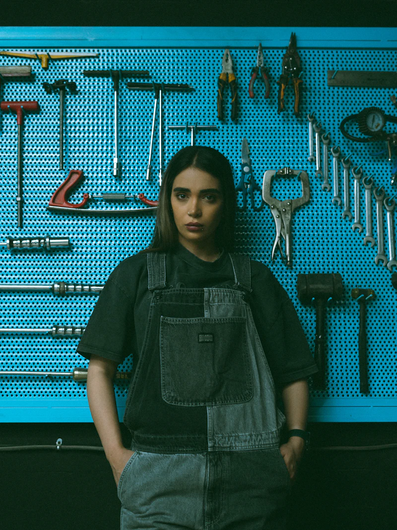 Overalls in front of a tool pegboard