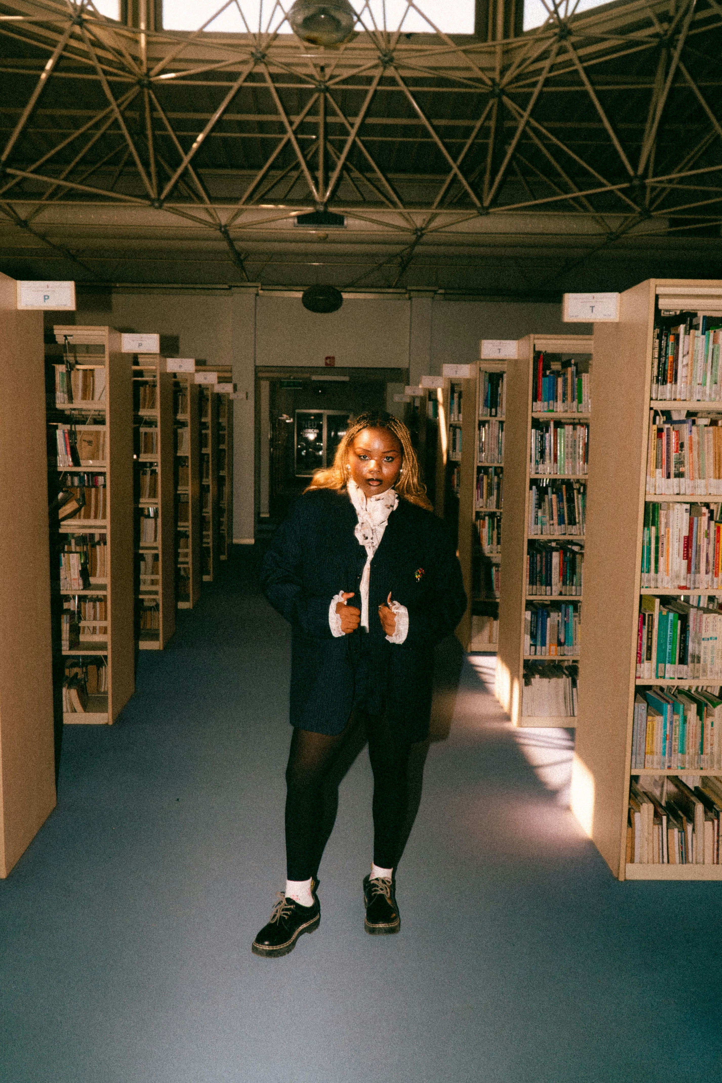 図書館にいる若い女性、本棚に囲まれている