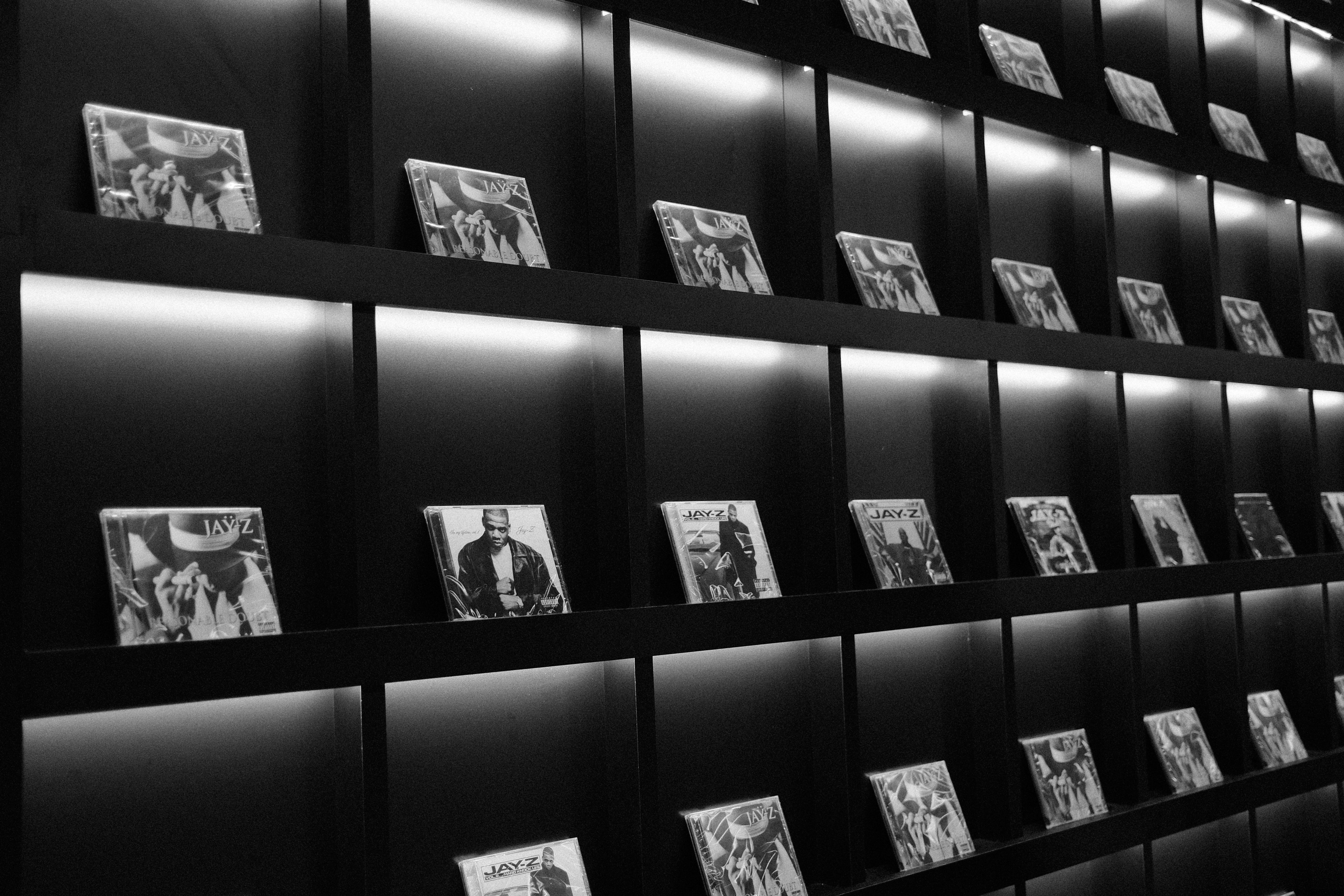 Rows of illuminated shelves displaying framed black and white photographs