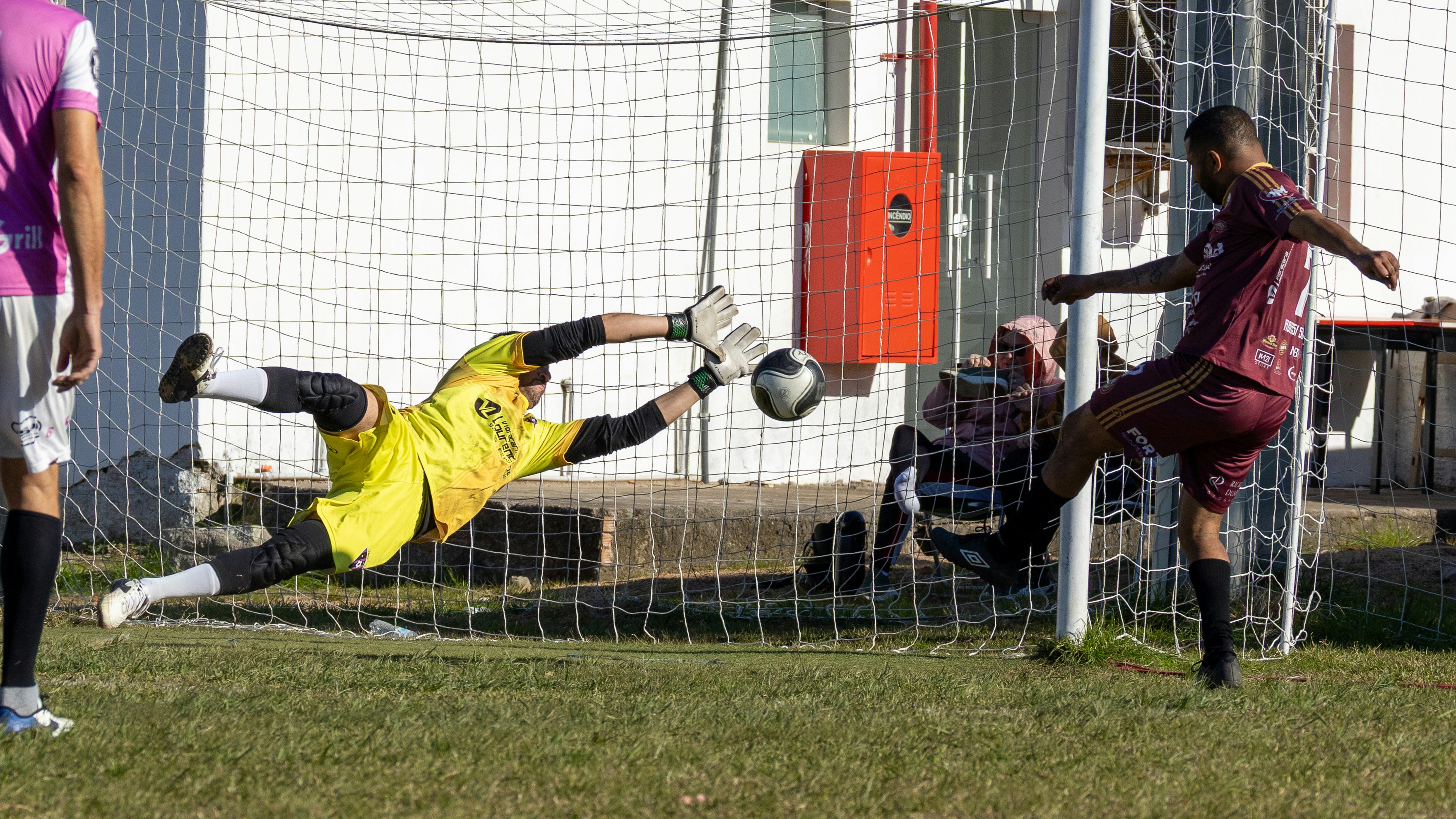 soccer goalkeeper penalty kick save - Soccer player shoots while goalkeeper dives for the save.