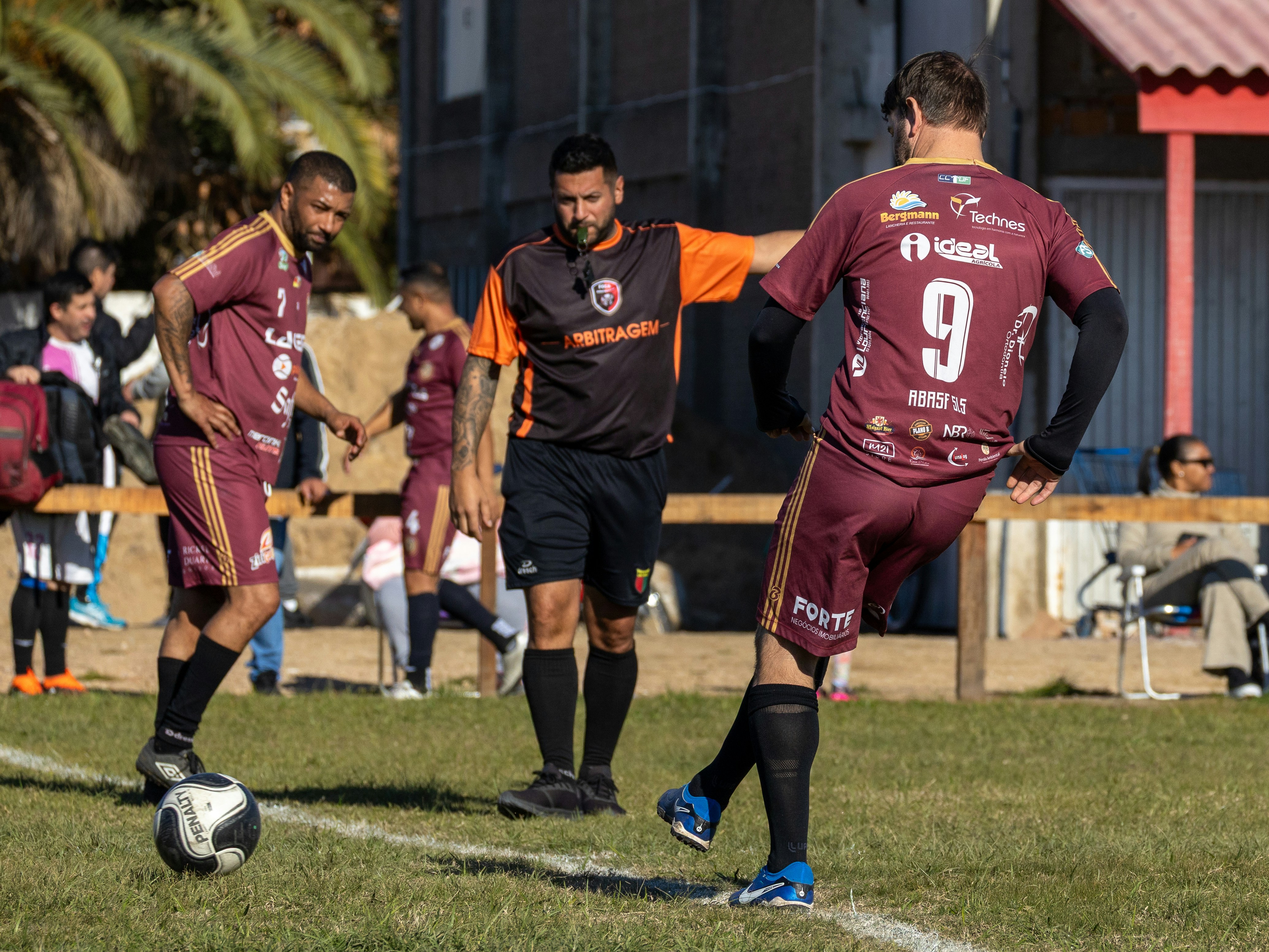 Referee watches soccer players on a green field