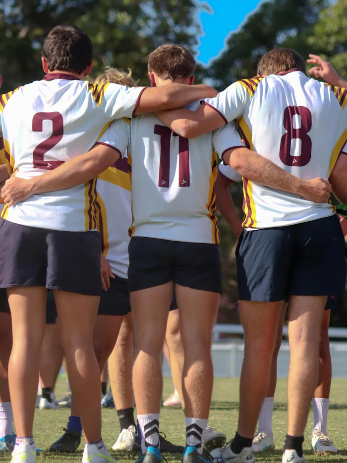 Tres jugadores de rugby abrazados en el campo