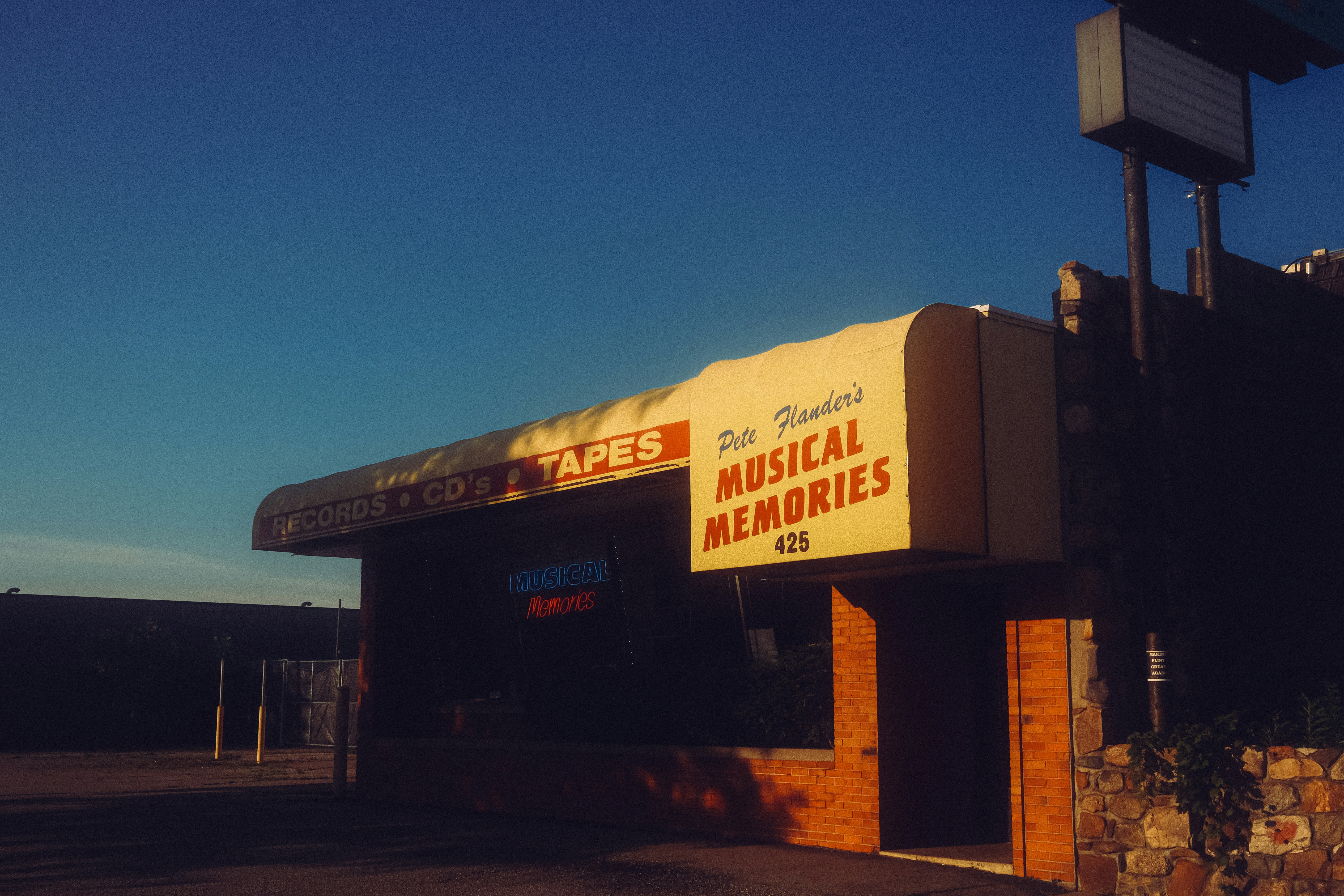 Building with "musical memories" and "games" signs under blue sky.