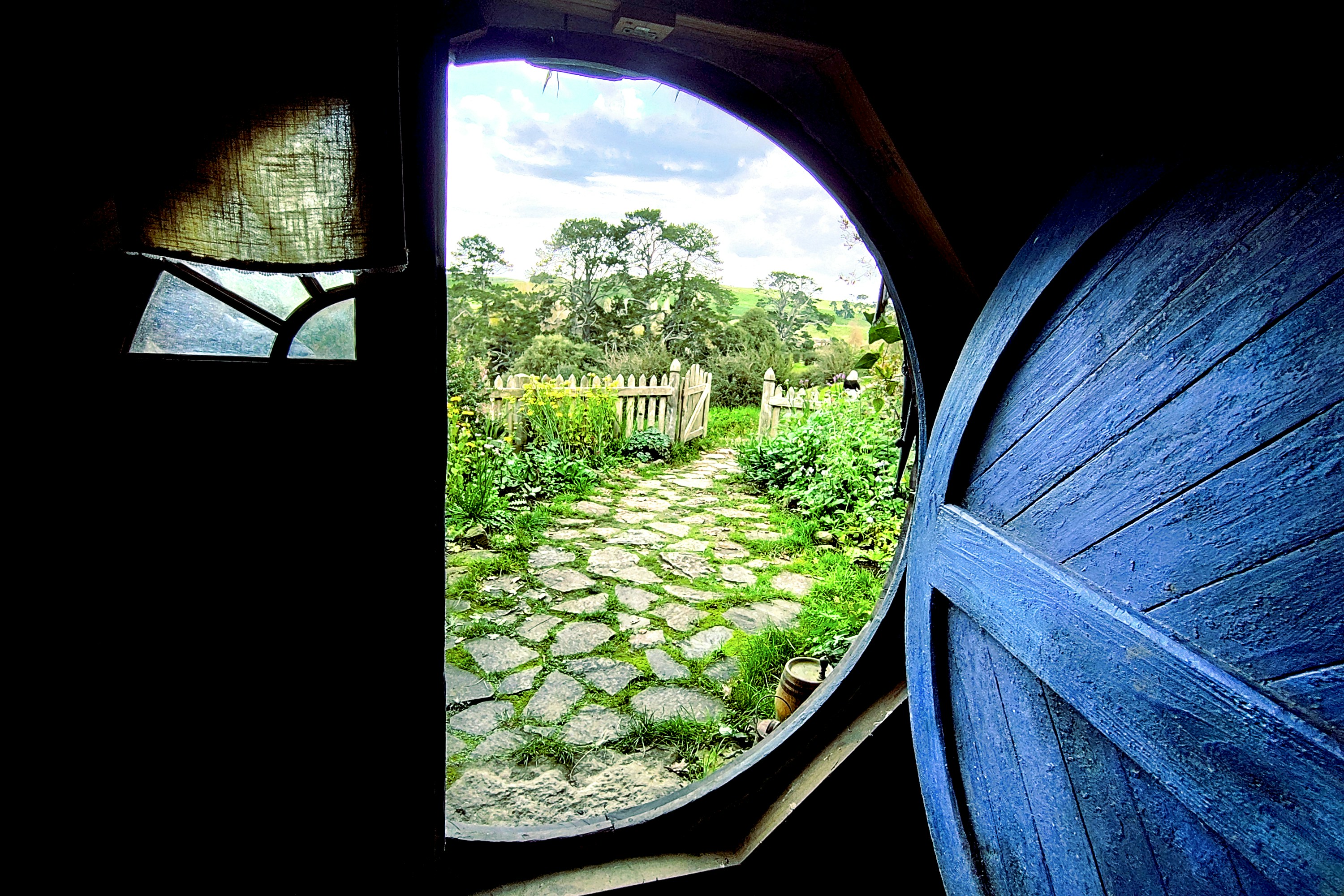 Vista da una porta rotonda su un rigoglioso sentiero da giardino.