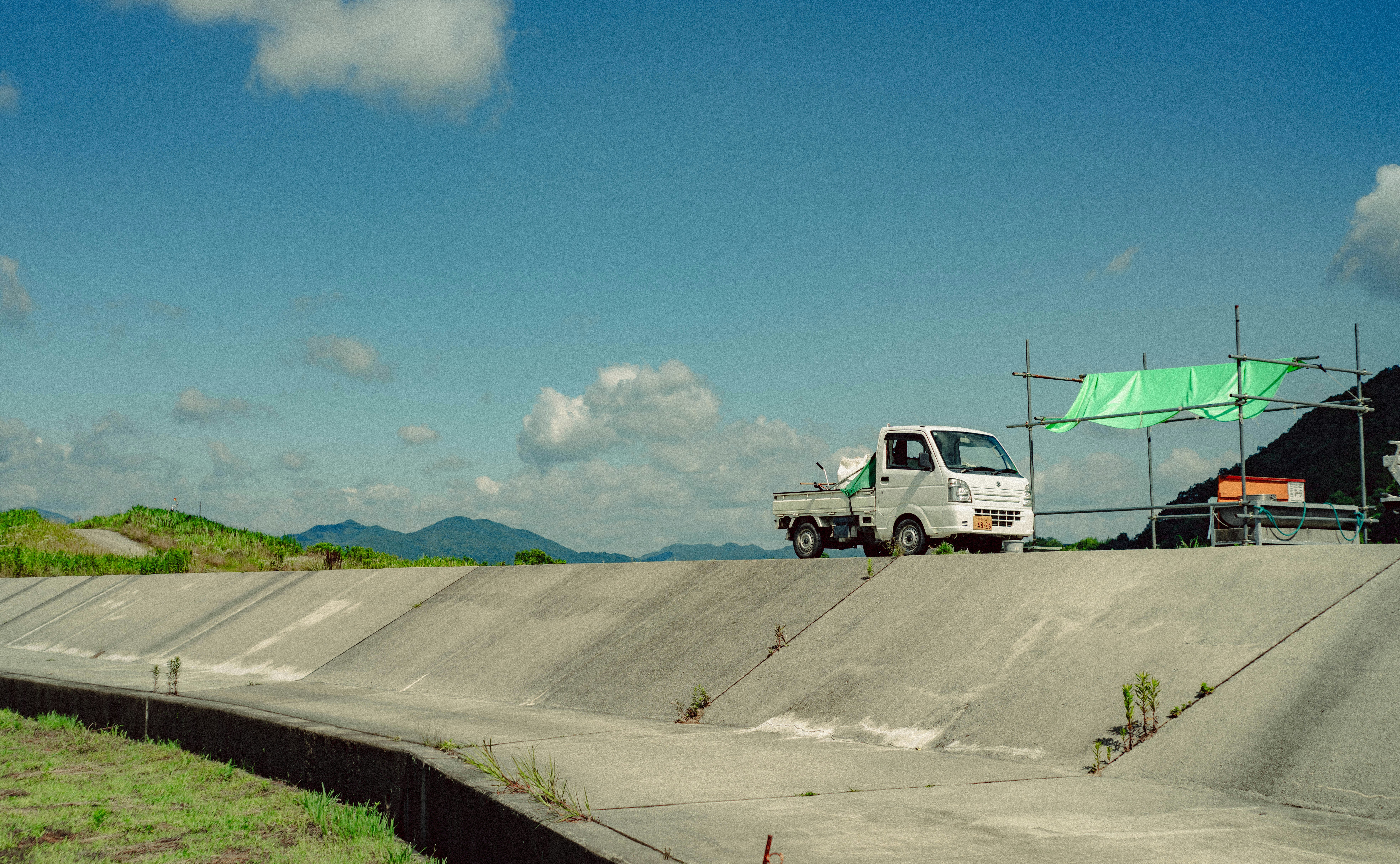 A white utility truck on a concrete embankment.