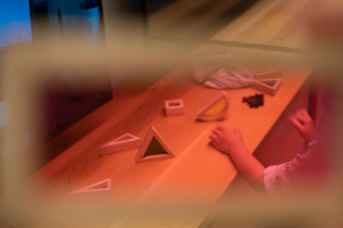A child's hands arranging real colorful wooden learning blocks