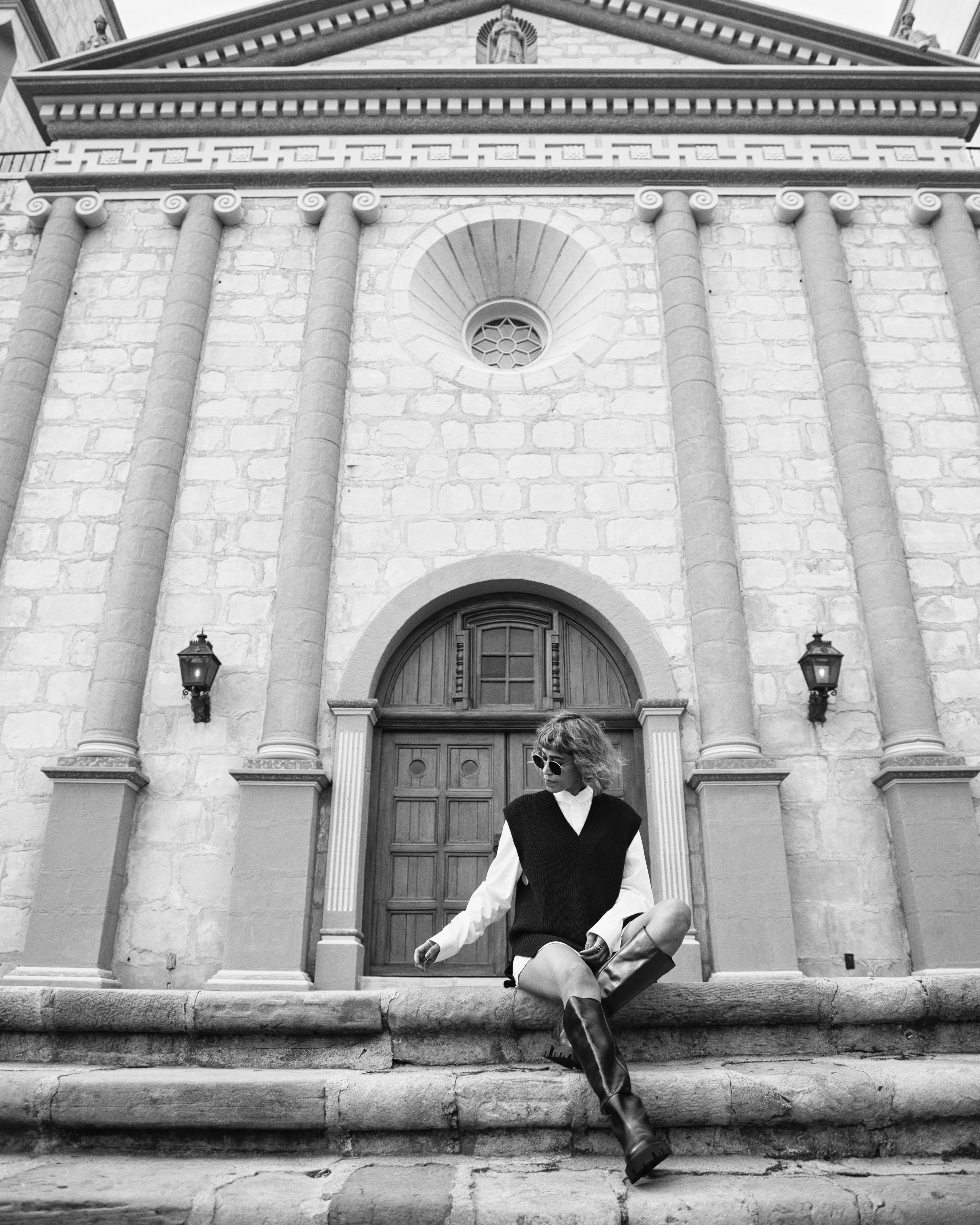 Femme assise sur des marches en pierre d’un bâtiment historique
