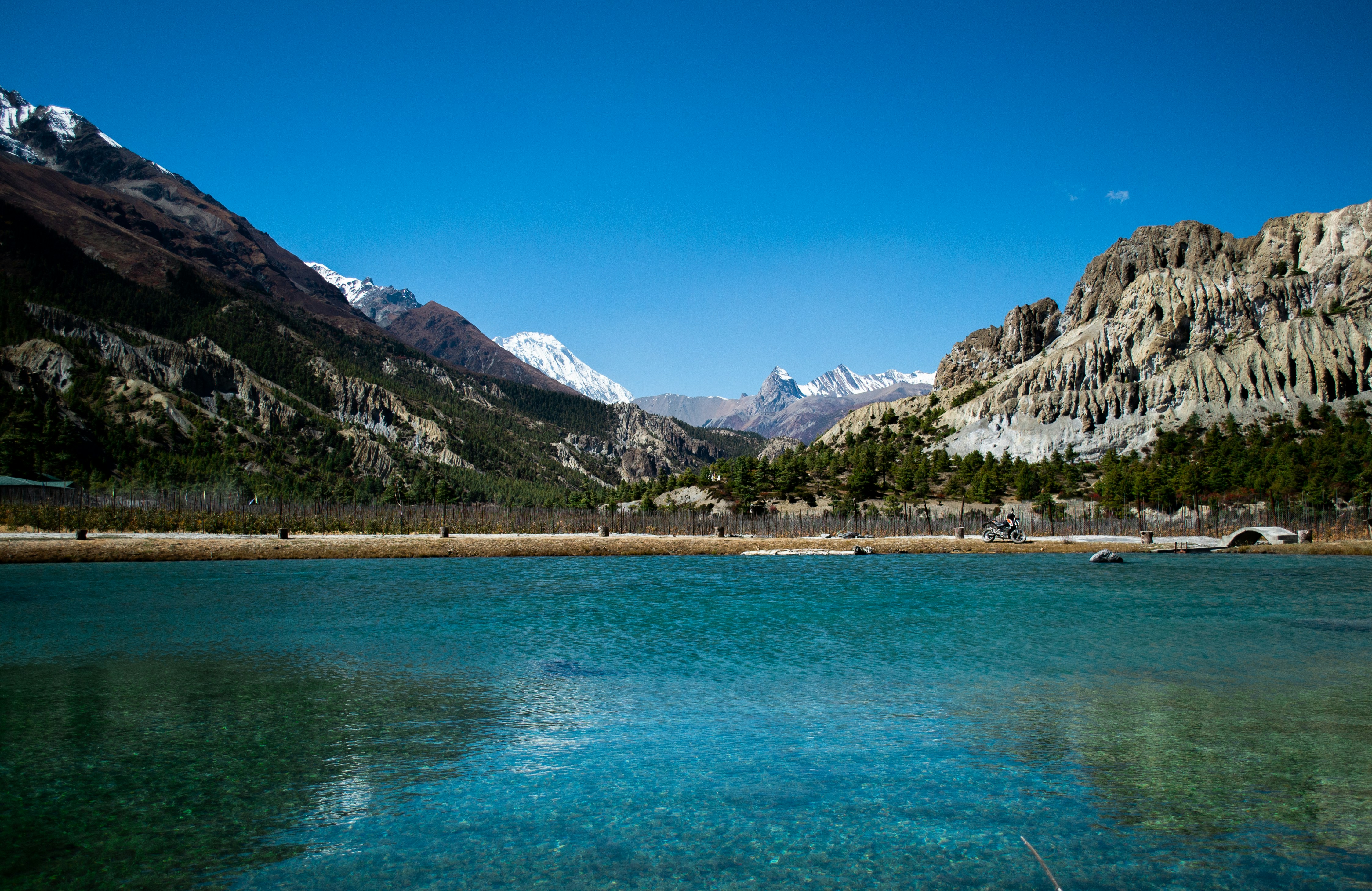 Serene blue lake surrounded by majestic snow-capped mountains.