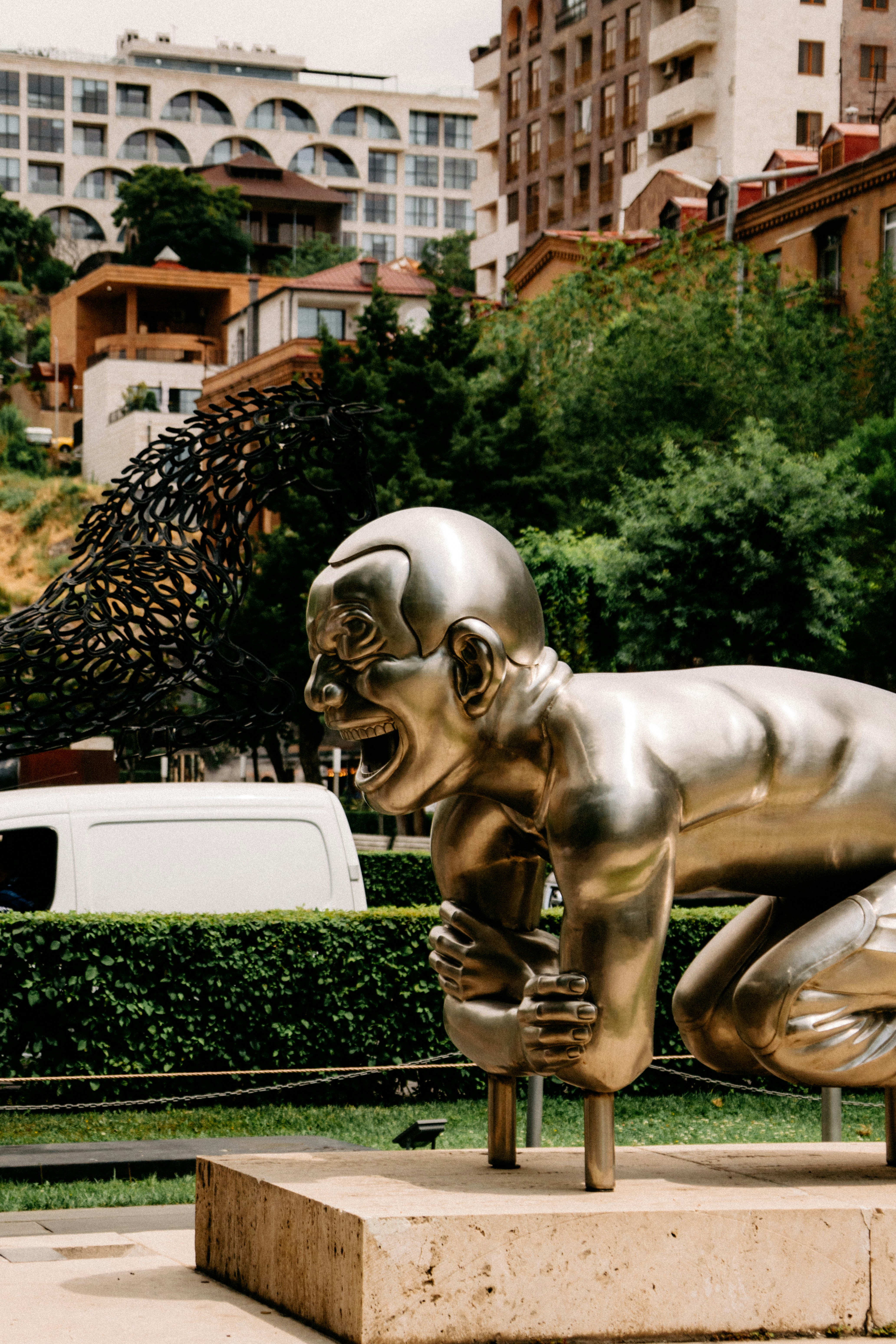 Modern golden statue of a man laughing in a city