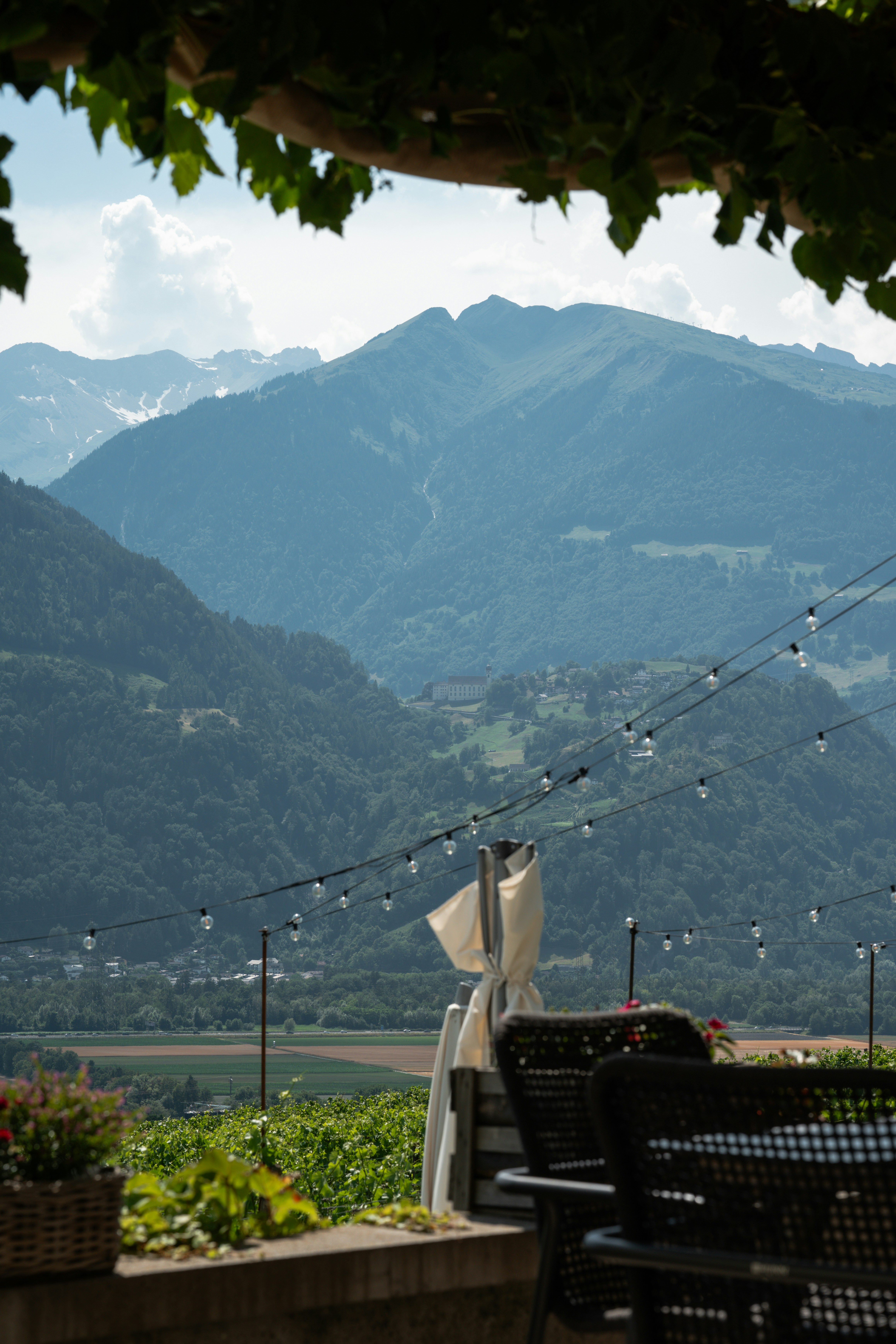 A scenic outdoor dining area overlooks a valley and mountains.