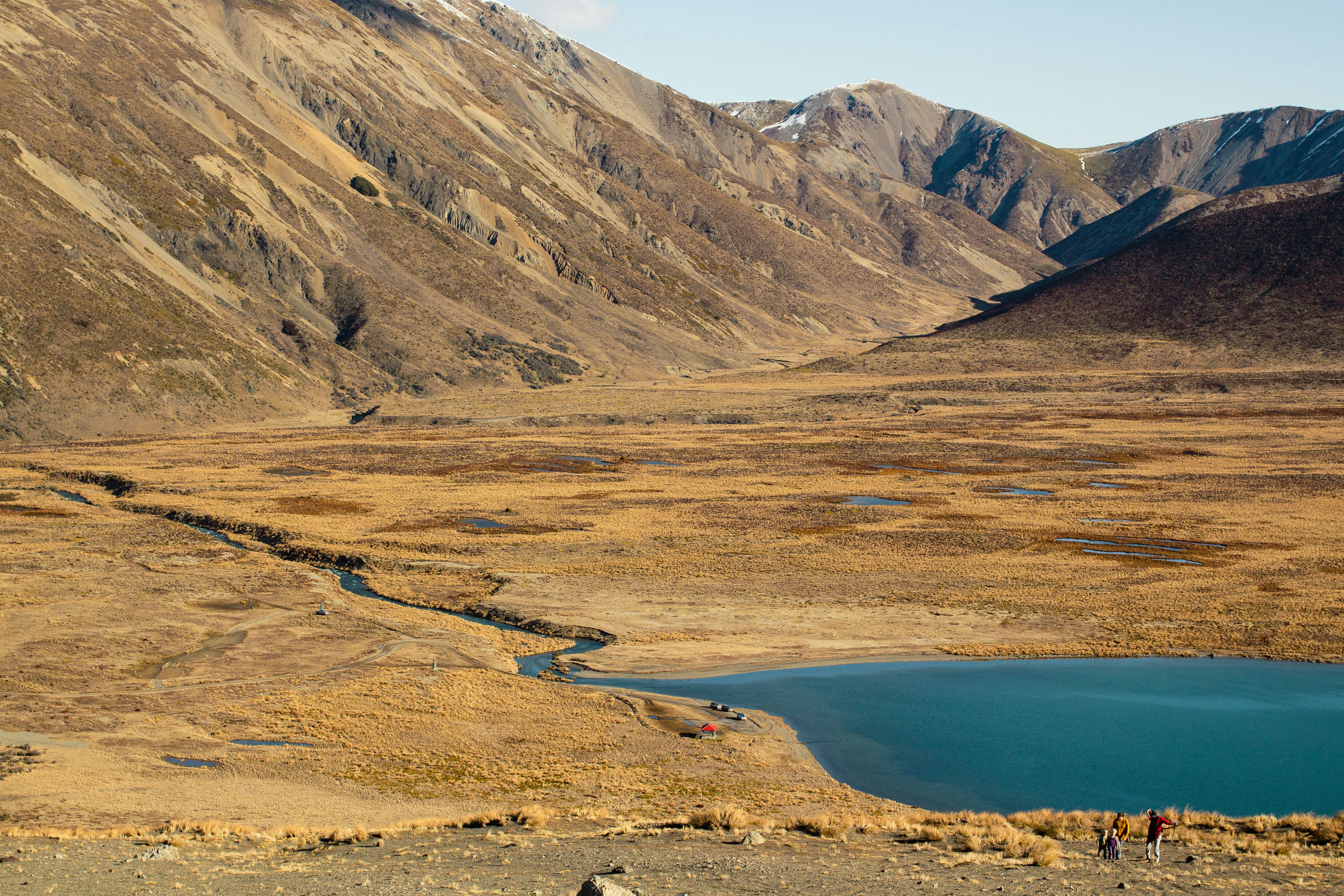 Golden hills, a blue lake, and distant mountains.