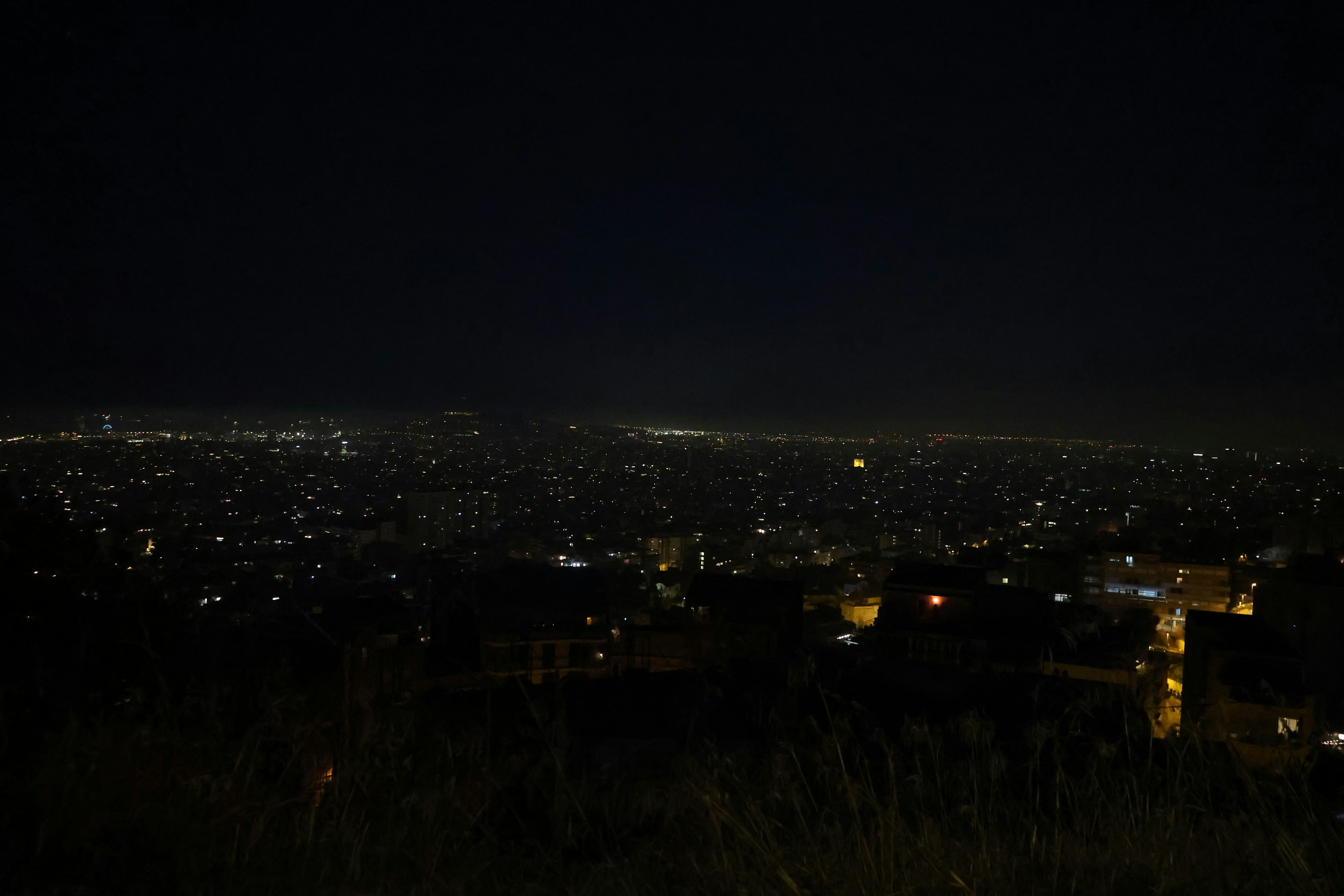 City lights twinkle across a dark night sky.