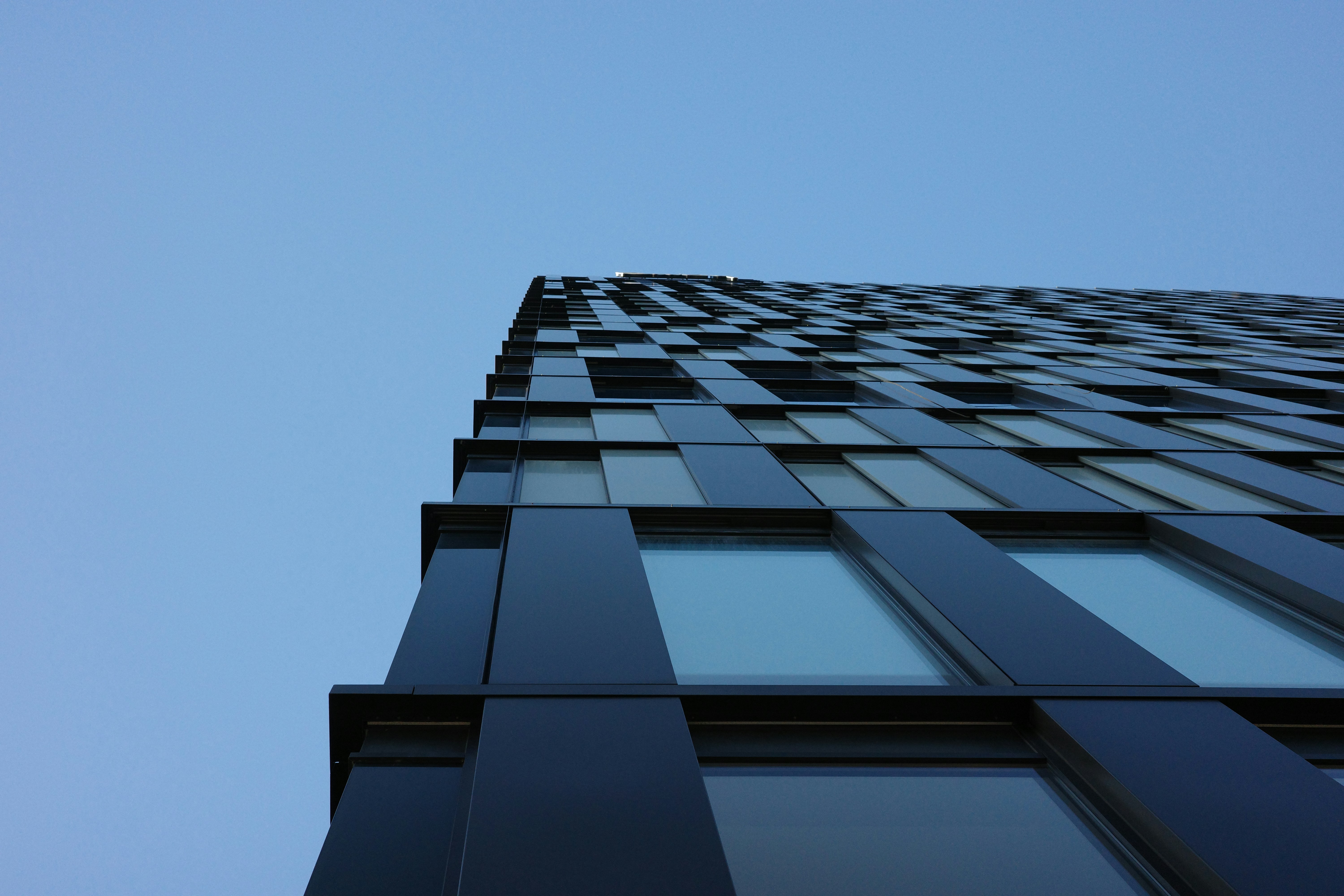 Modern building with dark facade against a clear blue sky