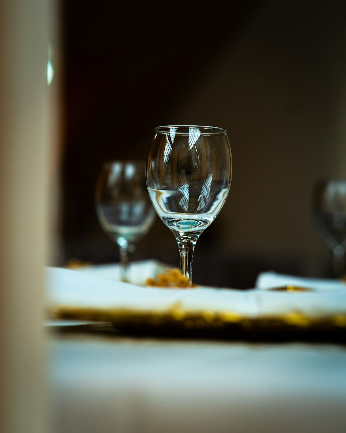 A clear wine glass catching golden evening light on a table