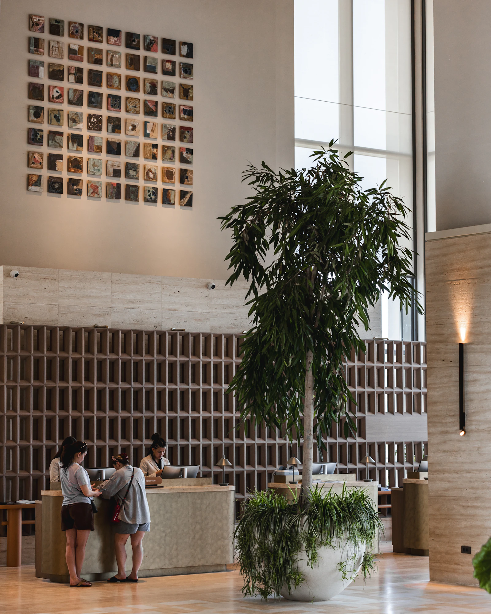 Le comptoir de réception d'un hôtel avec des clients qui arrivent