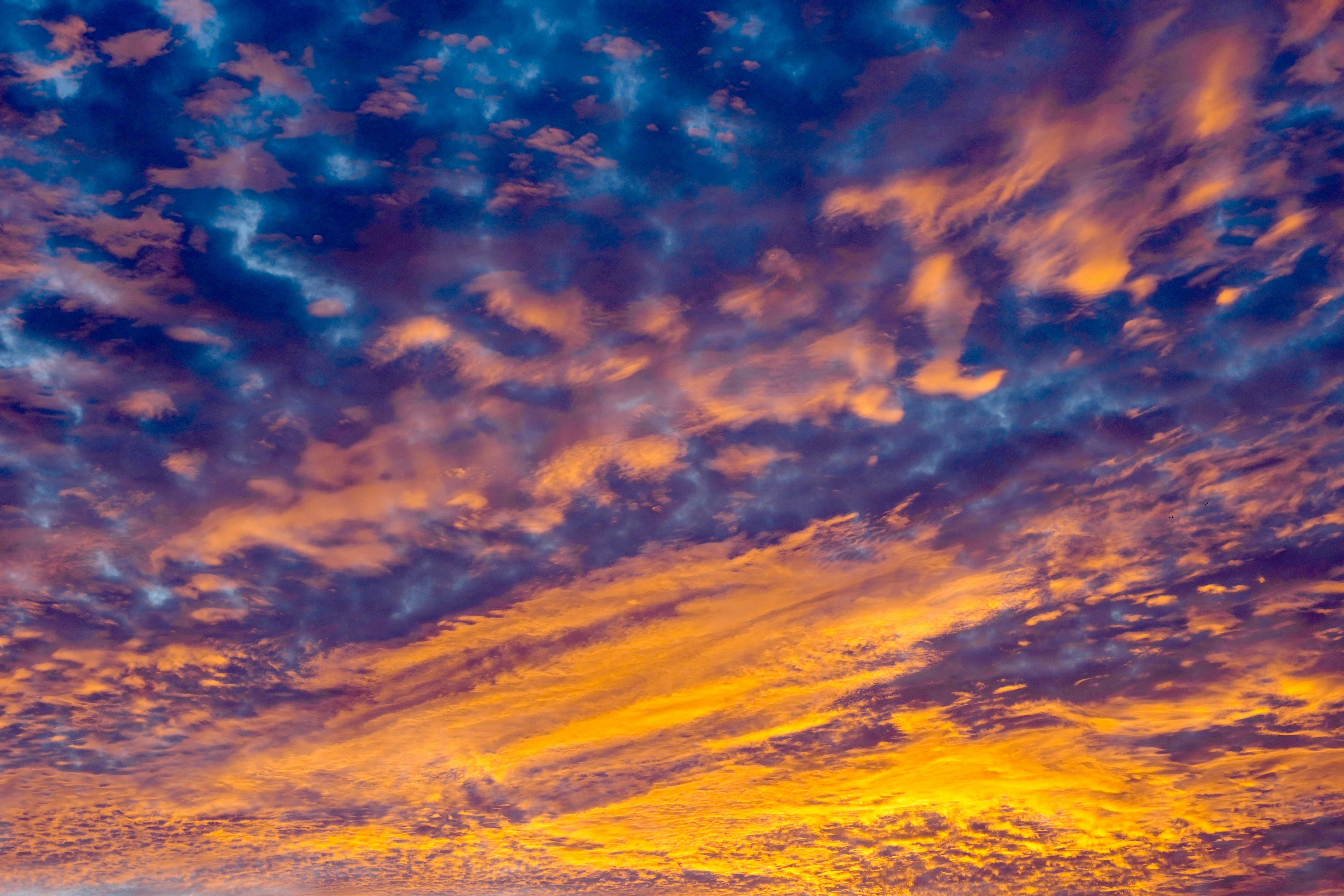 Vibrant orange and blue clouds fill the sky at sunset.
