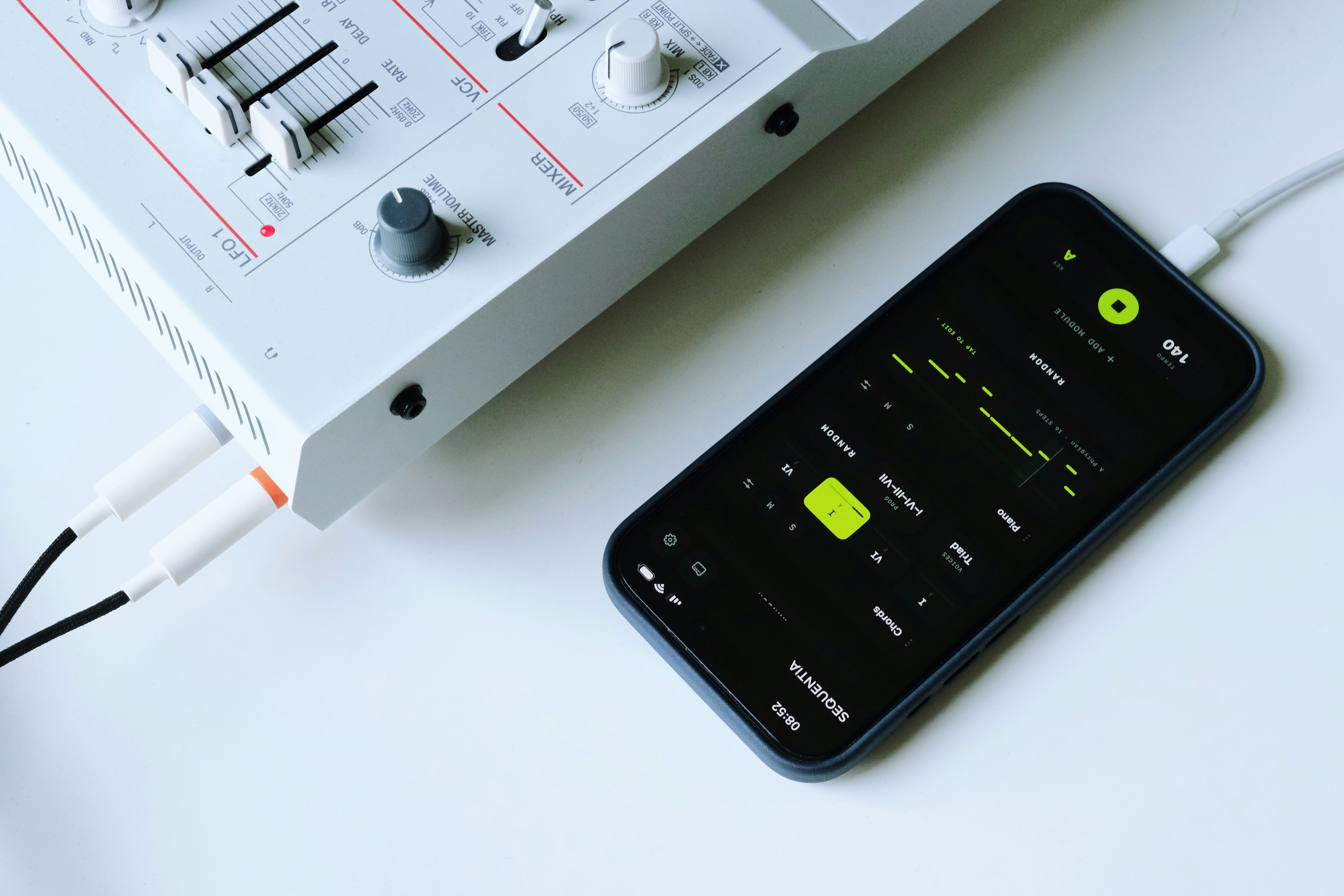 Smartphone connected to an audio mixer with a music app.