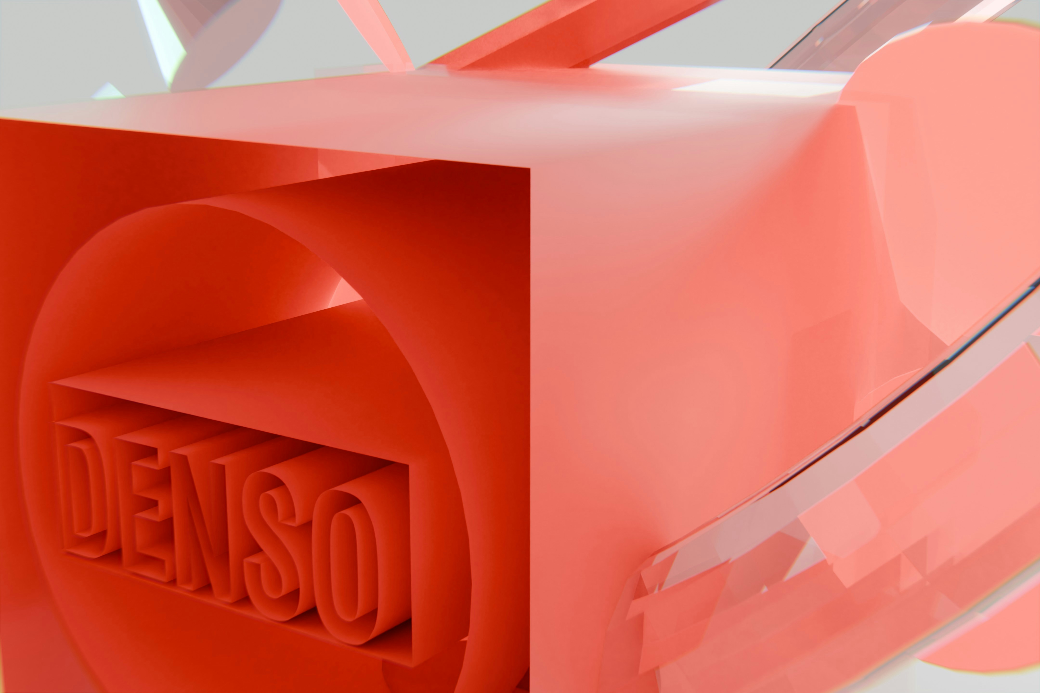 Red abstract 3D shape featuring the word 'denso'.